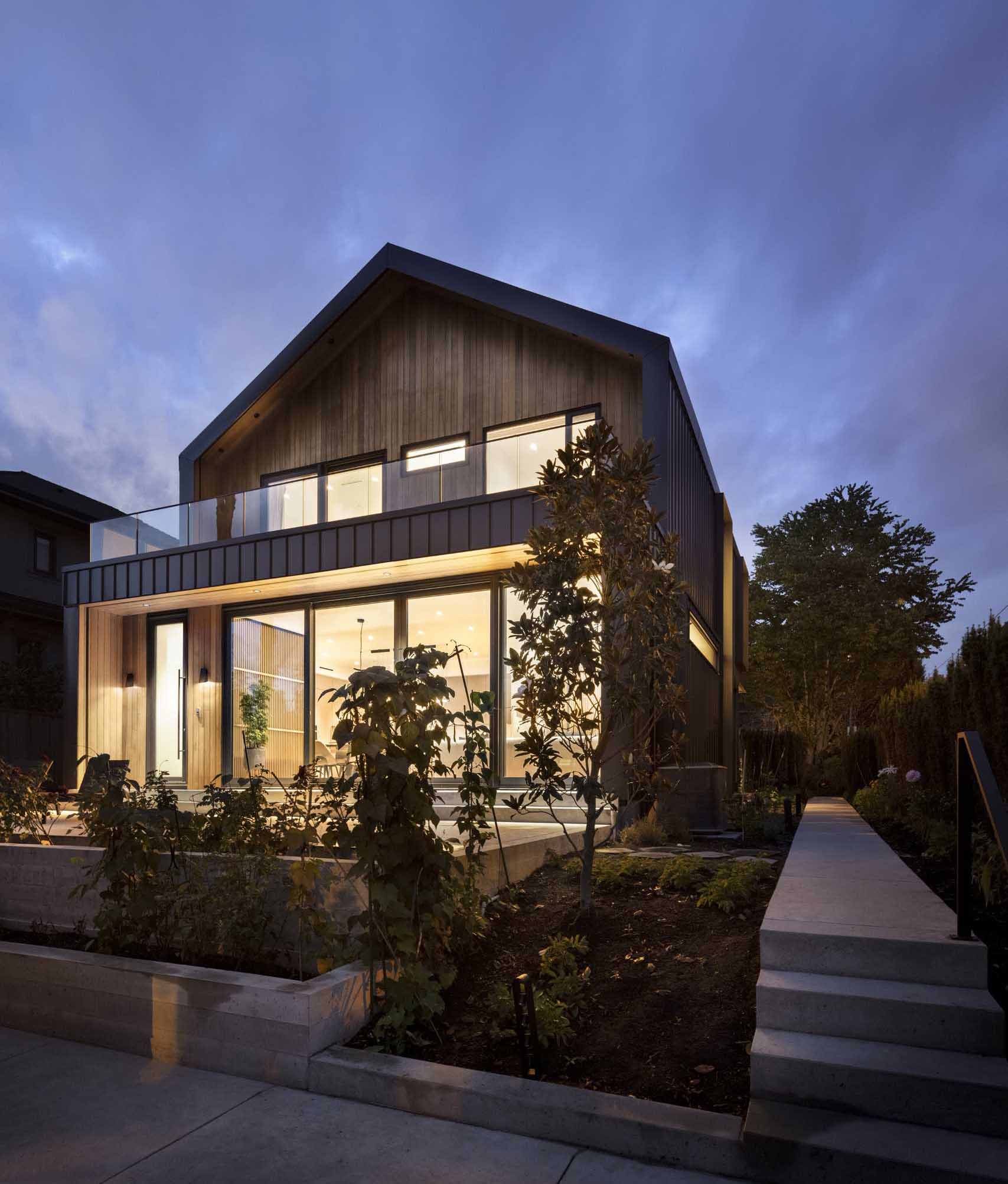 Large sliding glass doors at the rear of the house open to create one expansive and interconnected space consisting of the living, dining, kitchen, and patio.