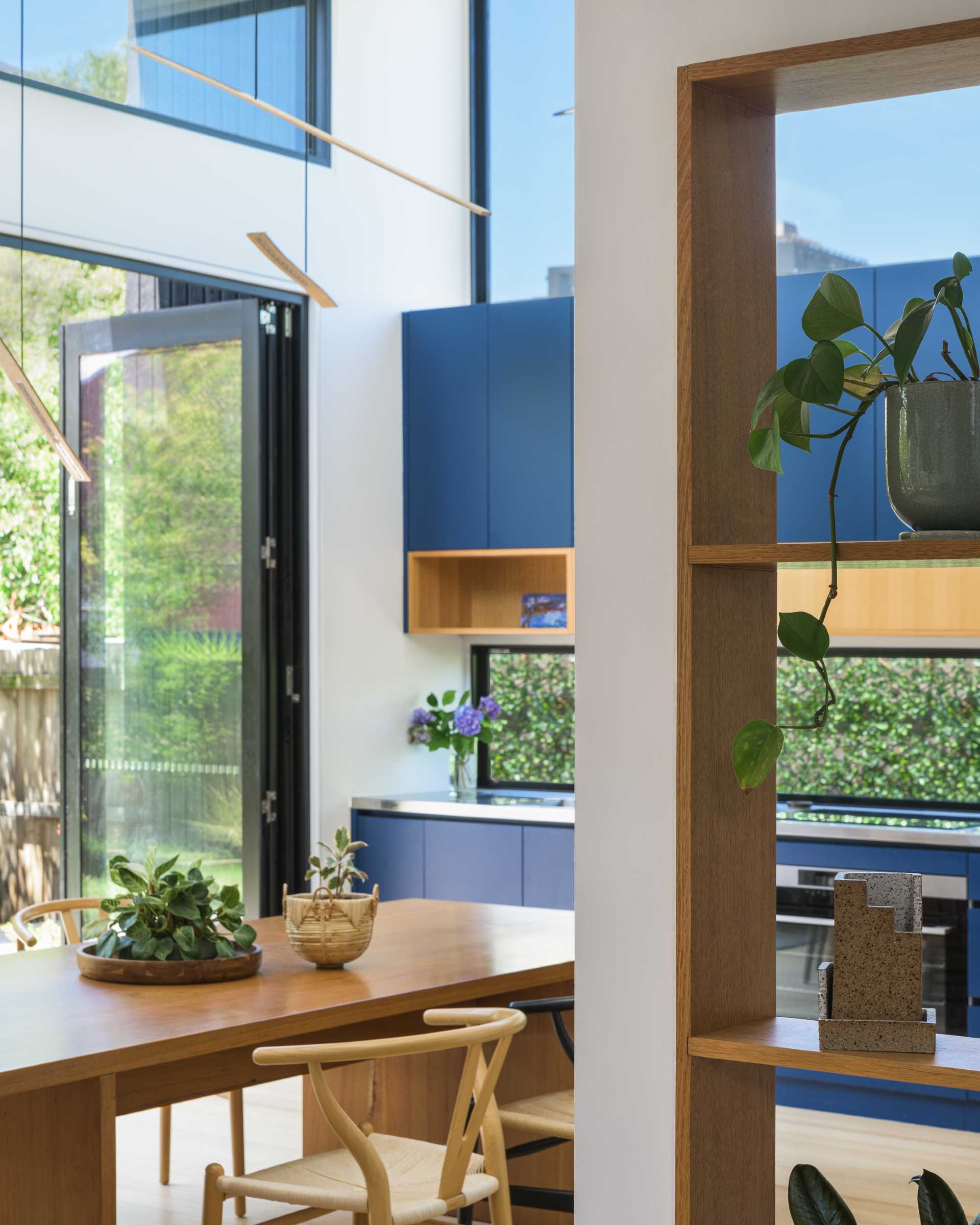 Instead of having a large island in this modern blue kitchen, the homeowners wanted a 'country kitchen' with a large table around which people gather to prepare food.