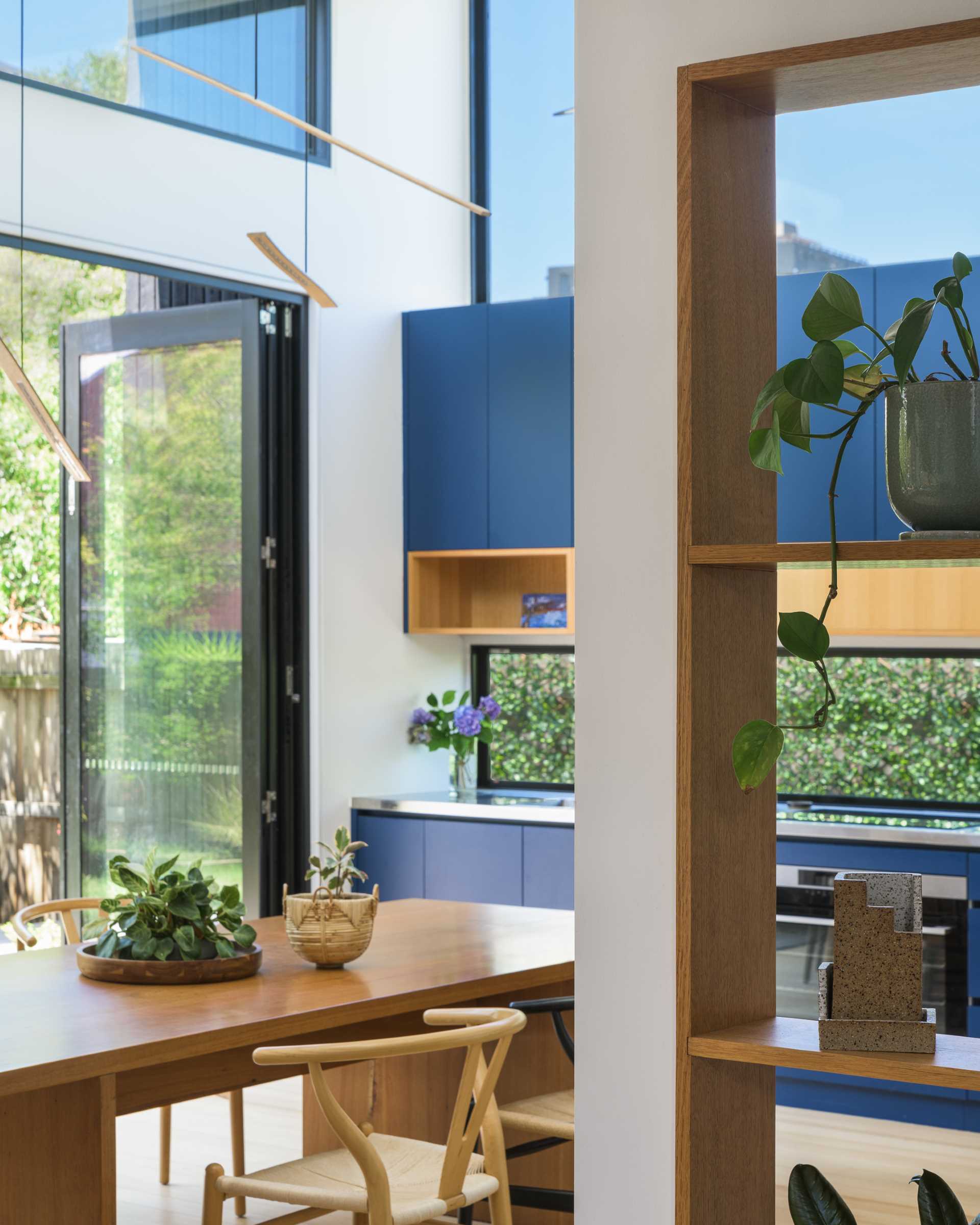 Instead of having a large island in this modern blue kitchen, the homeowners wanted a 'country kitchen' with a large table around which people gather to prepare food. 