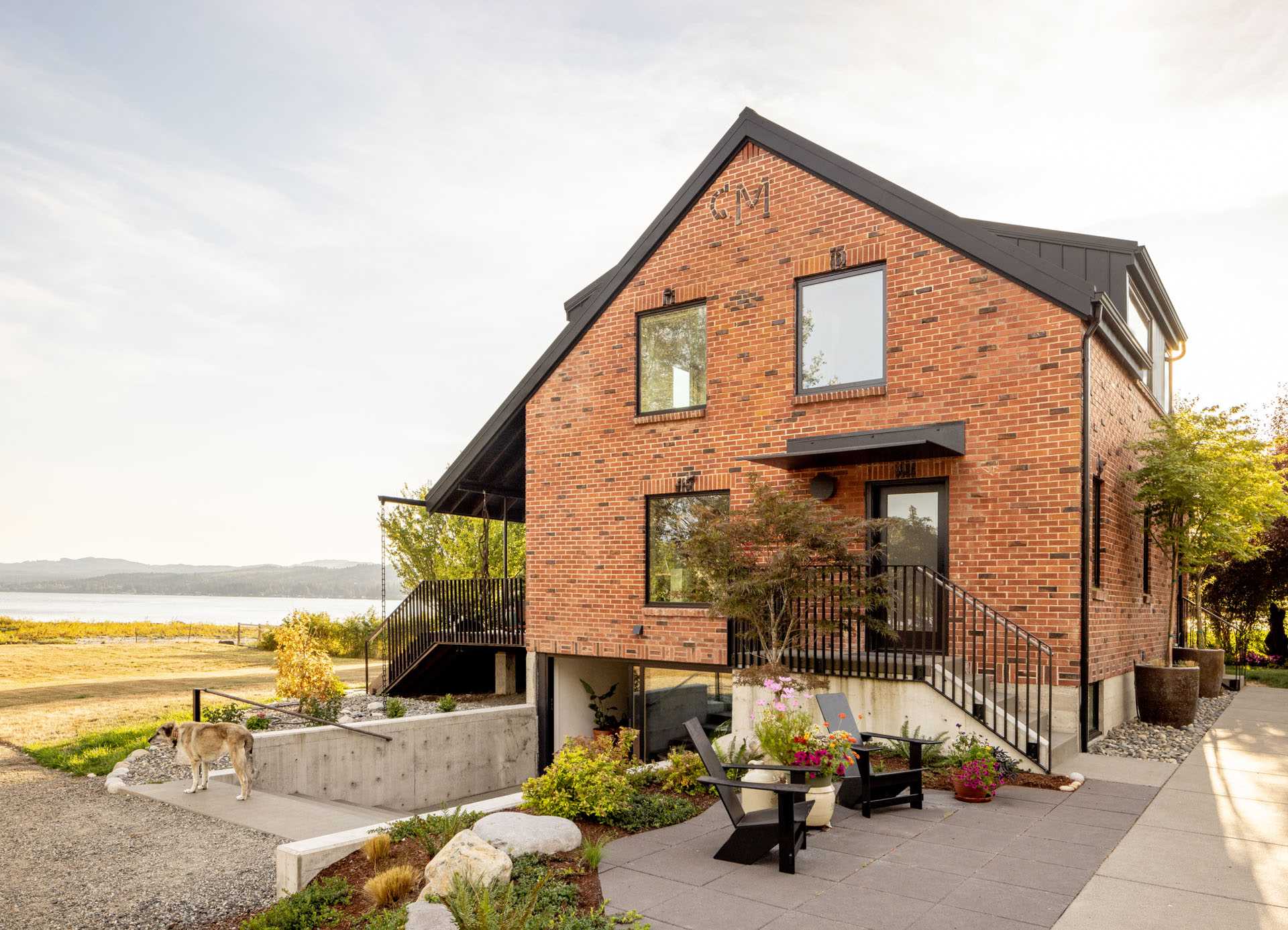 A remodeled brick farmhouse now includes a large patio and steps that lead down to a lower level with a media room.