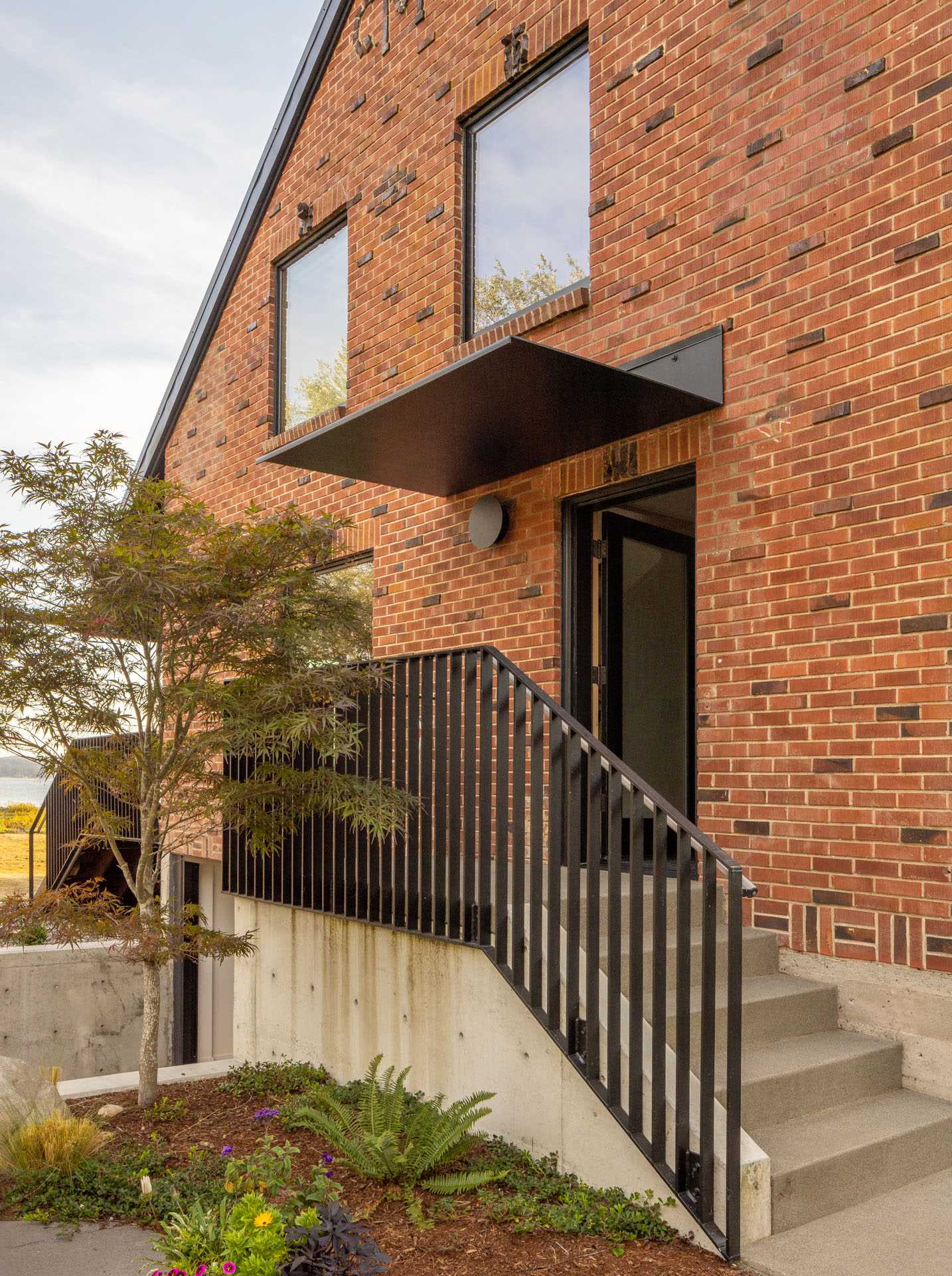 A remodeled brick farmhouse with a new covered front door.