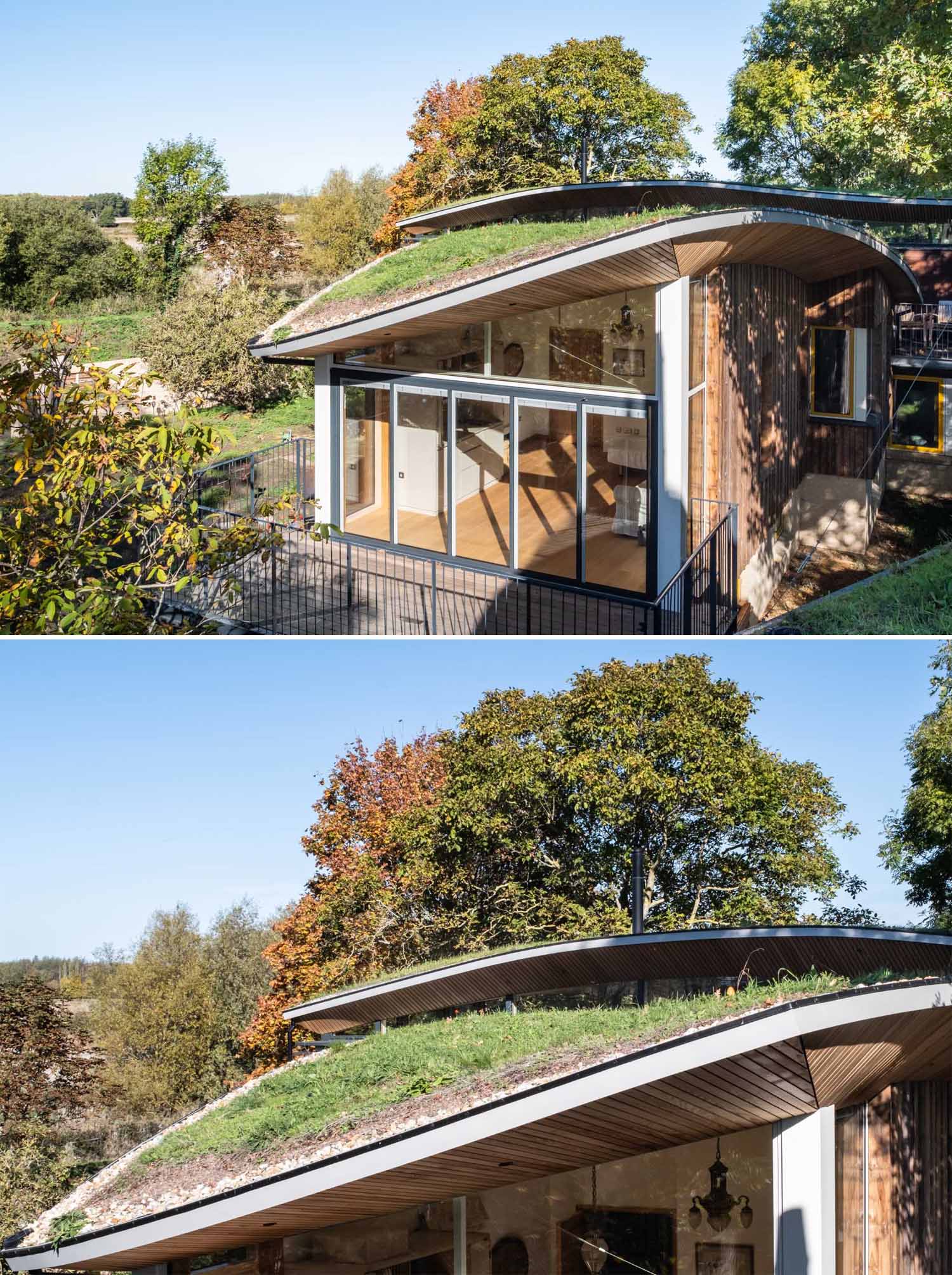 A modern cabin with overhanging wood-lined eaves and curved green roofs.