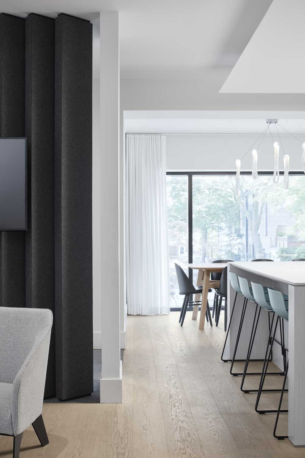 Wood flooring has been used throughout this modern home, and the nearby dining room looks out onto the street.