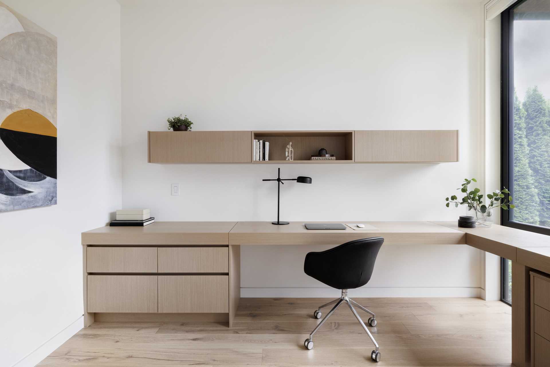 A home office includes a custom-designed desk that wraps from the wall and around to the window.