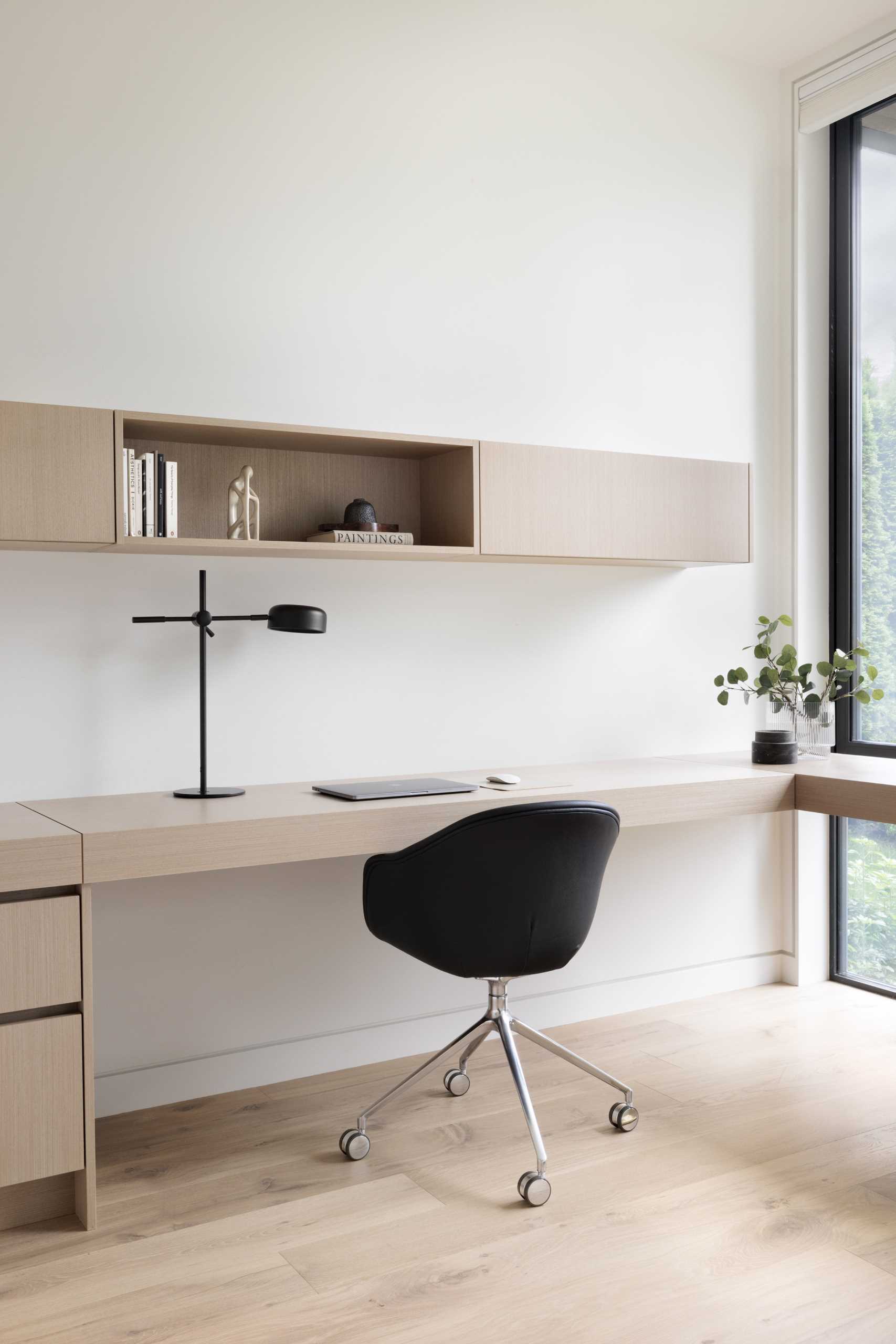 A home office includes a custom-designed desk that wraps from the wall and around to the window.