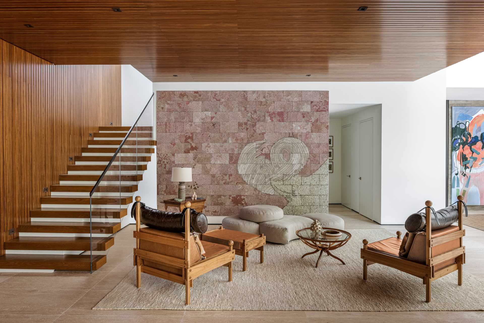 In this sitting room with a wood ceiling, there's a Giuseppe Scapinelli coffee table, Sergio Rodrigues armchairs, and artwork by Elias Sime.