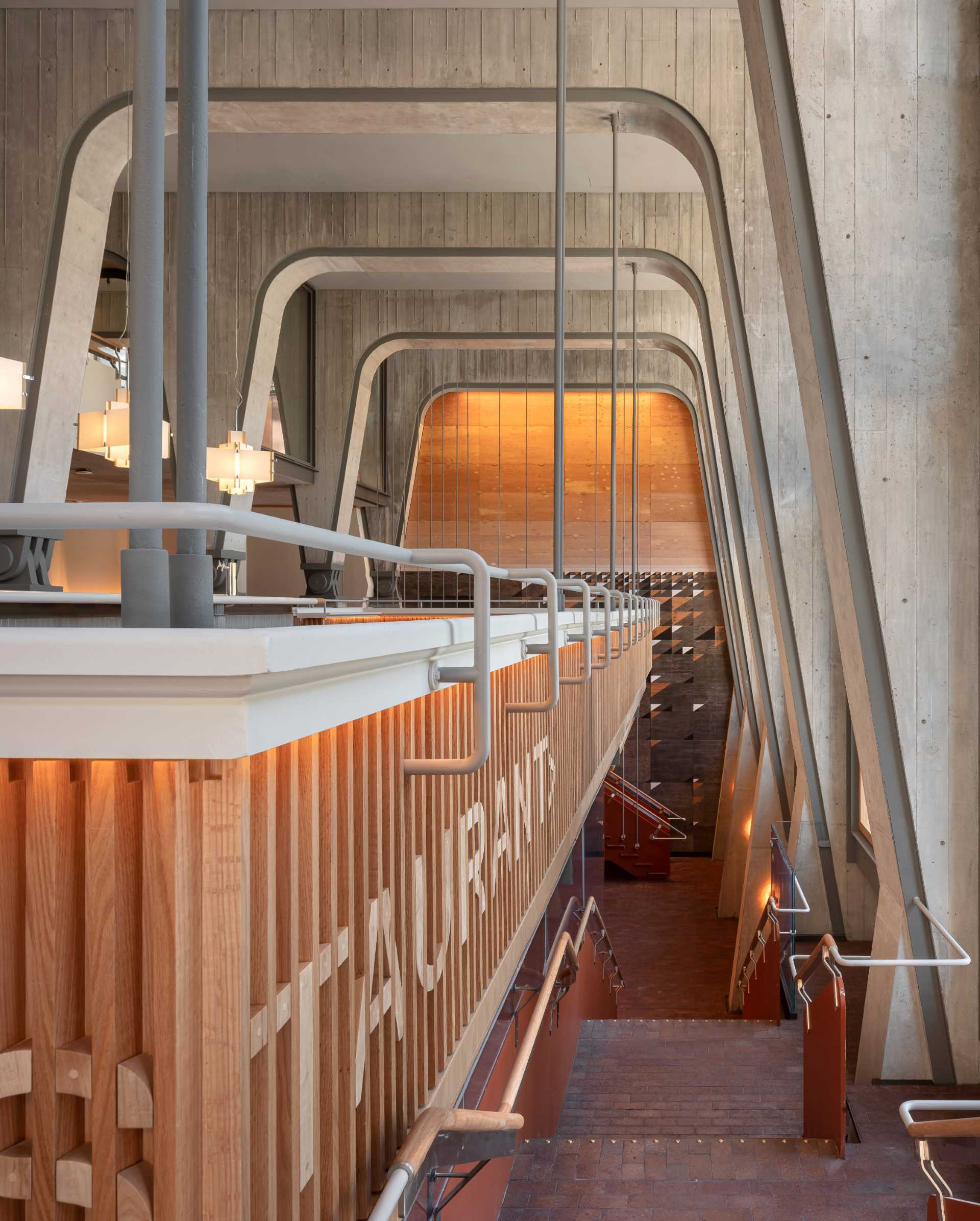 A modern hotel lobby with a restaurant on a lower level.