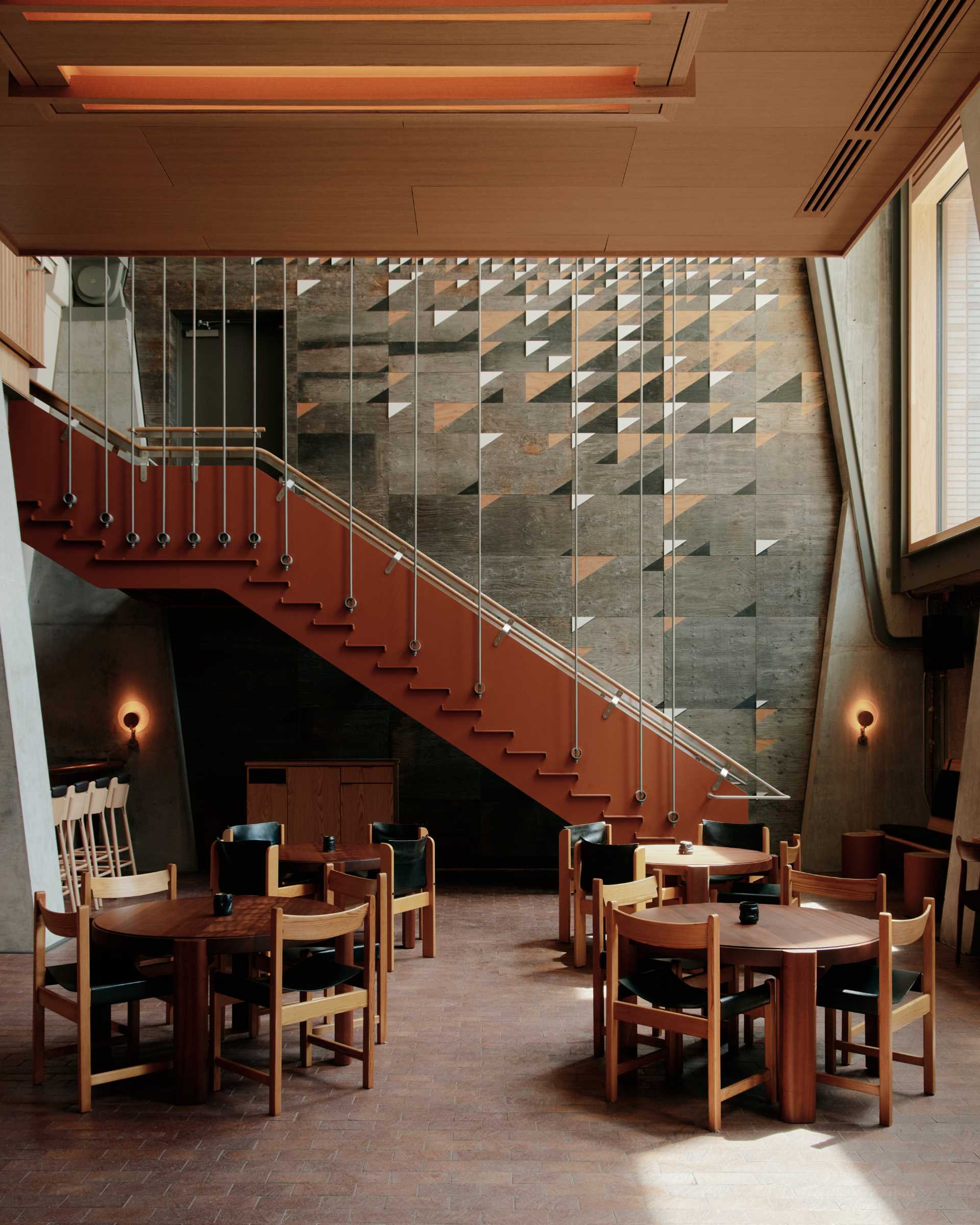 A modern restaurant in the Ace Hotel, Toronto, has stairs that lead down to it.