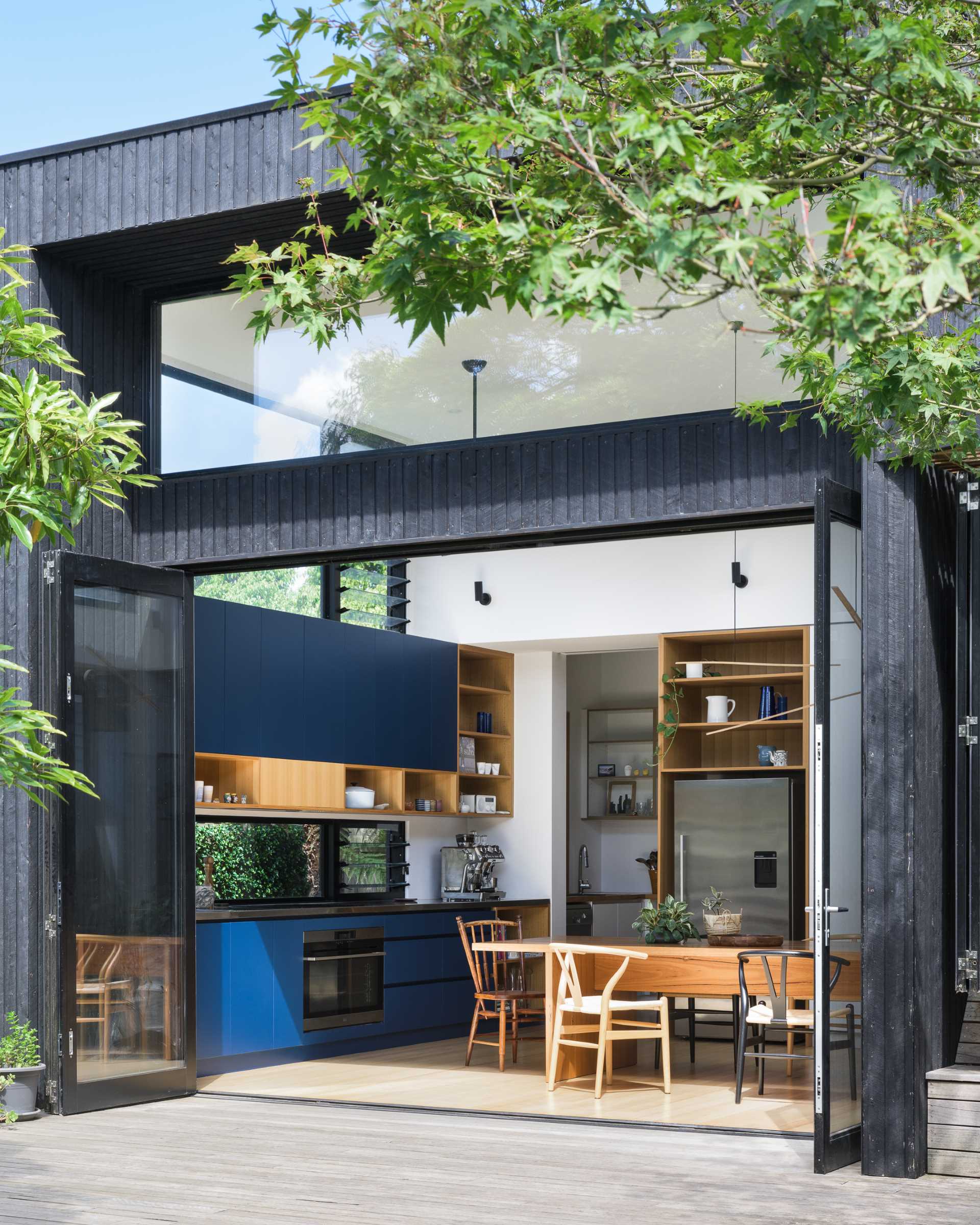 This modern rear extension has has bi-fold doors that open to connect the kitchen and dining area to the yard.