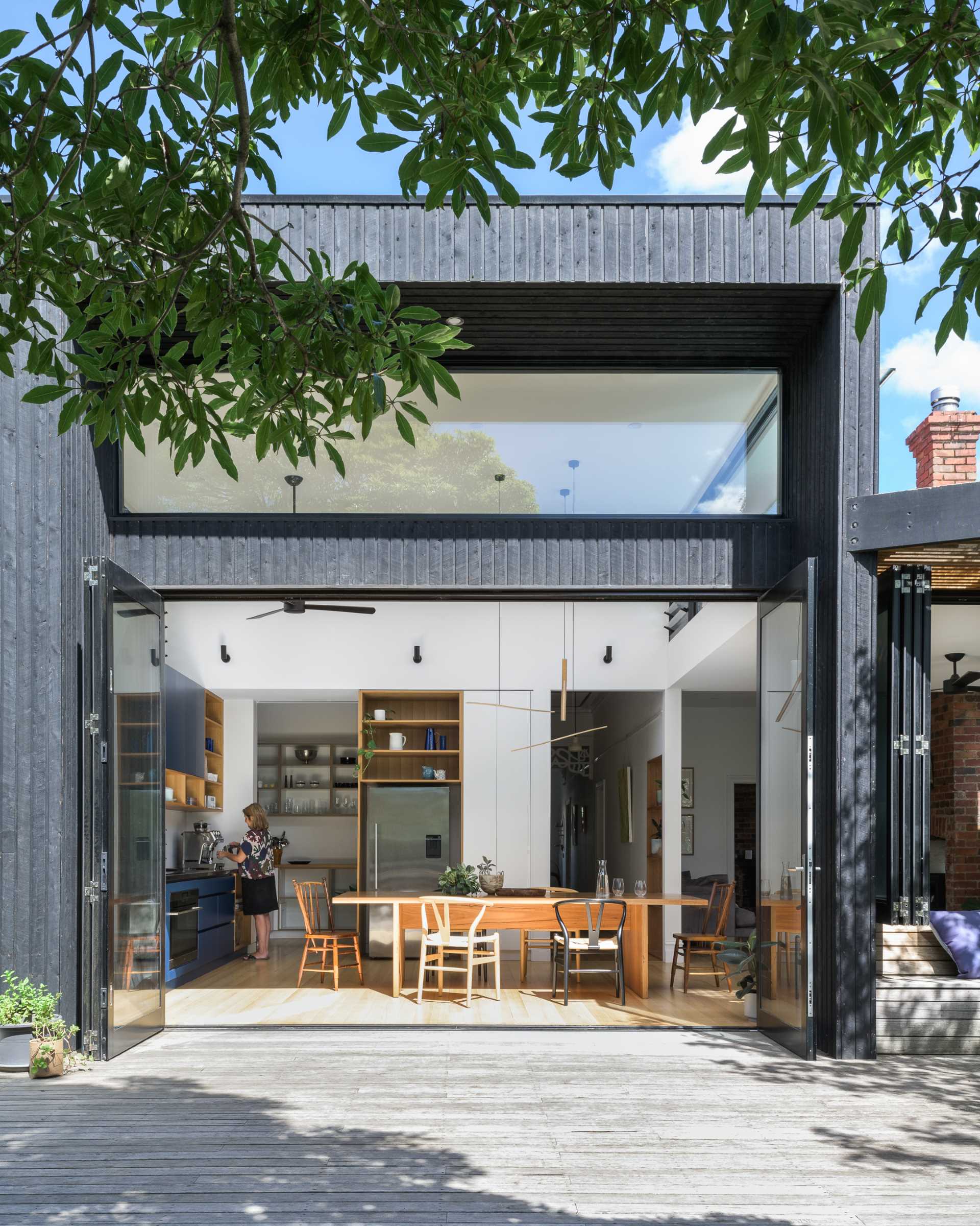 This modern rear extension has has bi-fold doors that open to connect the kitchen and dining area to the yard.