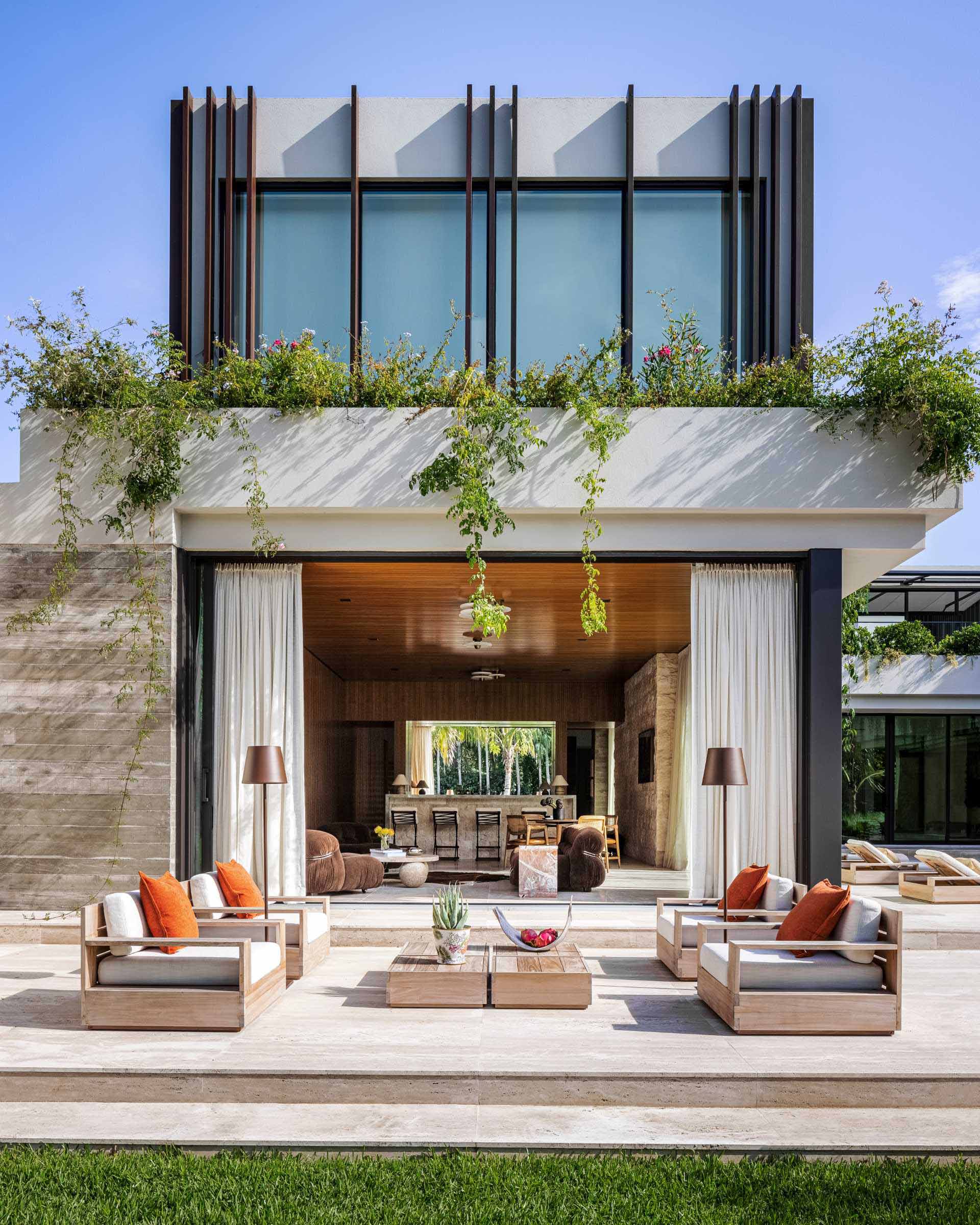 The exterior facade of this modern home features rough-cut Jerusalem tile and exposed board-formed concrete, as well the vertical Ipe wood fins and planters that wrap around the second storey.