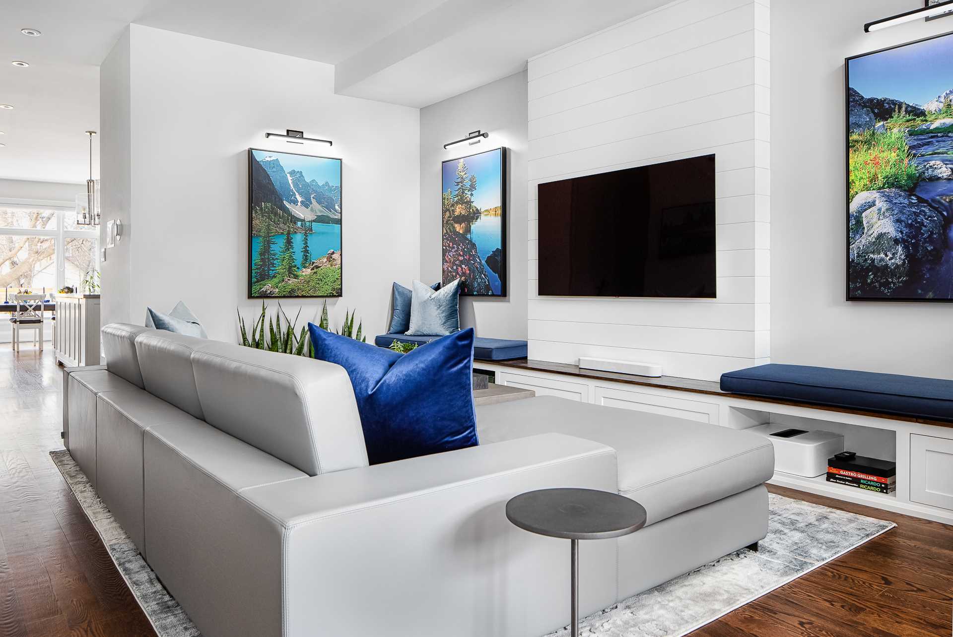 In this modern living room, a low modern sectional was included to comfortably seat the client’s family of three during movie nights. Custom-designed benches were designed opposite a coffee table increasing the seating options and storage, allowing the space to be used practically when guests visit.