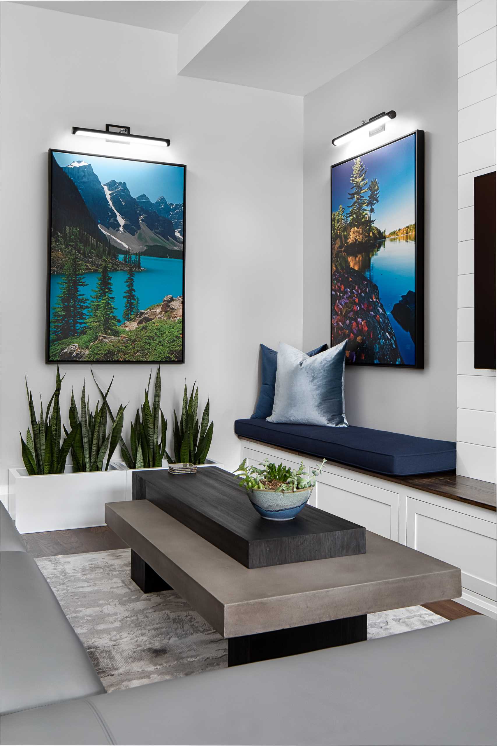 A modern living room with large art prints, and built-in benches that include hidden storage.