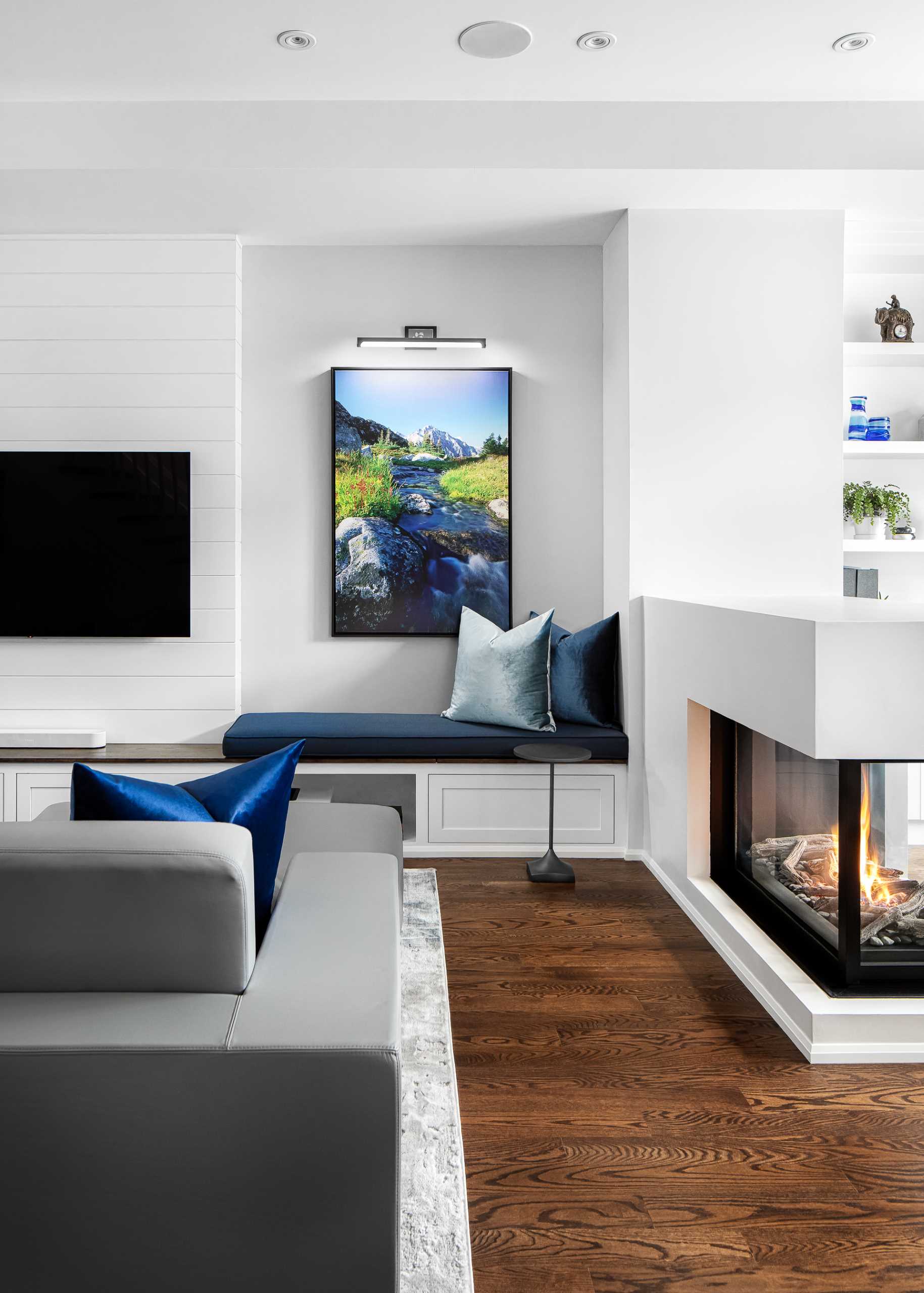 A low three-sided fireplace acts as a room divider separated the living room from the home office.