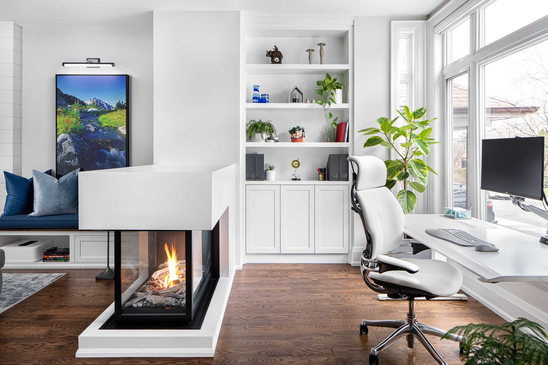 This home office is positioned in front of the large windows, while custom-designed shelving and cabinetry ensures the desk is clutter free while giving the opportunity to display decor and accessories.