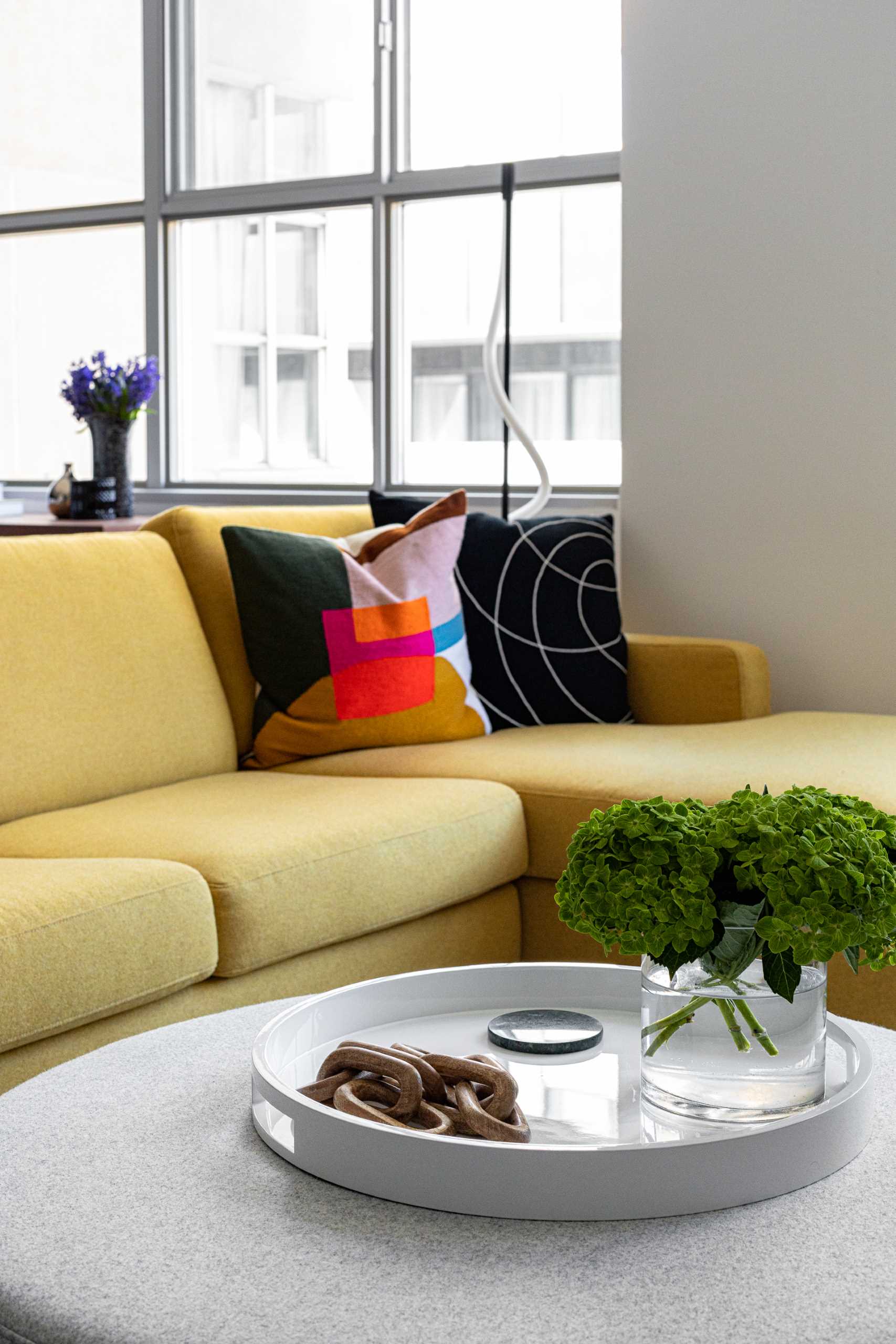 The living room in this modern loft apartment is home to a bright yellow sectional, as well as a large rug by Christoph Niemann.