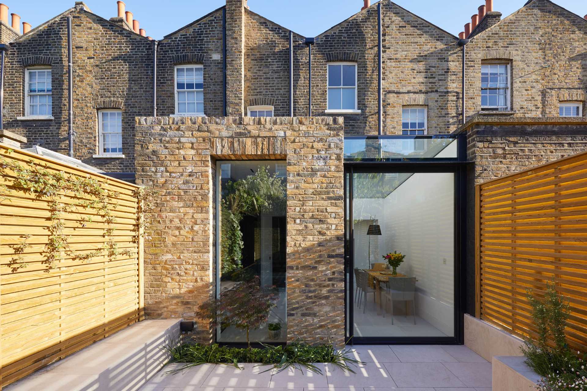 A modern brick and glass rear addition for a Grade II Listed Town House in Greater London, England.