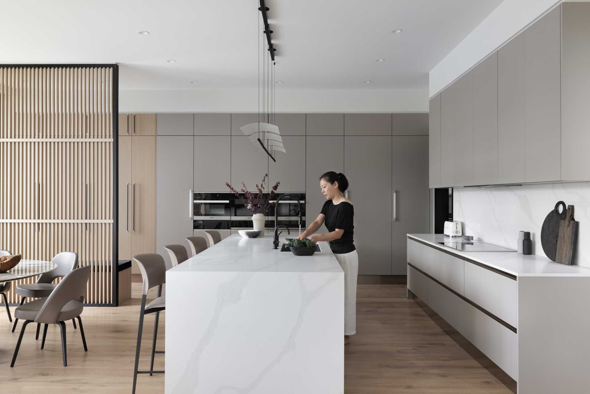 A modern kitchen includes minimalist cabinets and a large island.