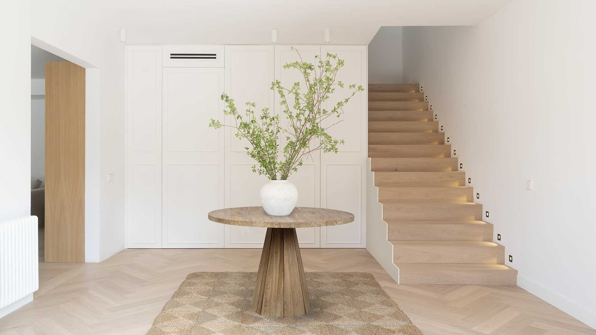A small foyer with a hidden powder room and stairs that lead to the upper floor of the home.