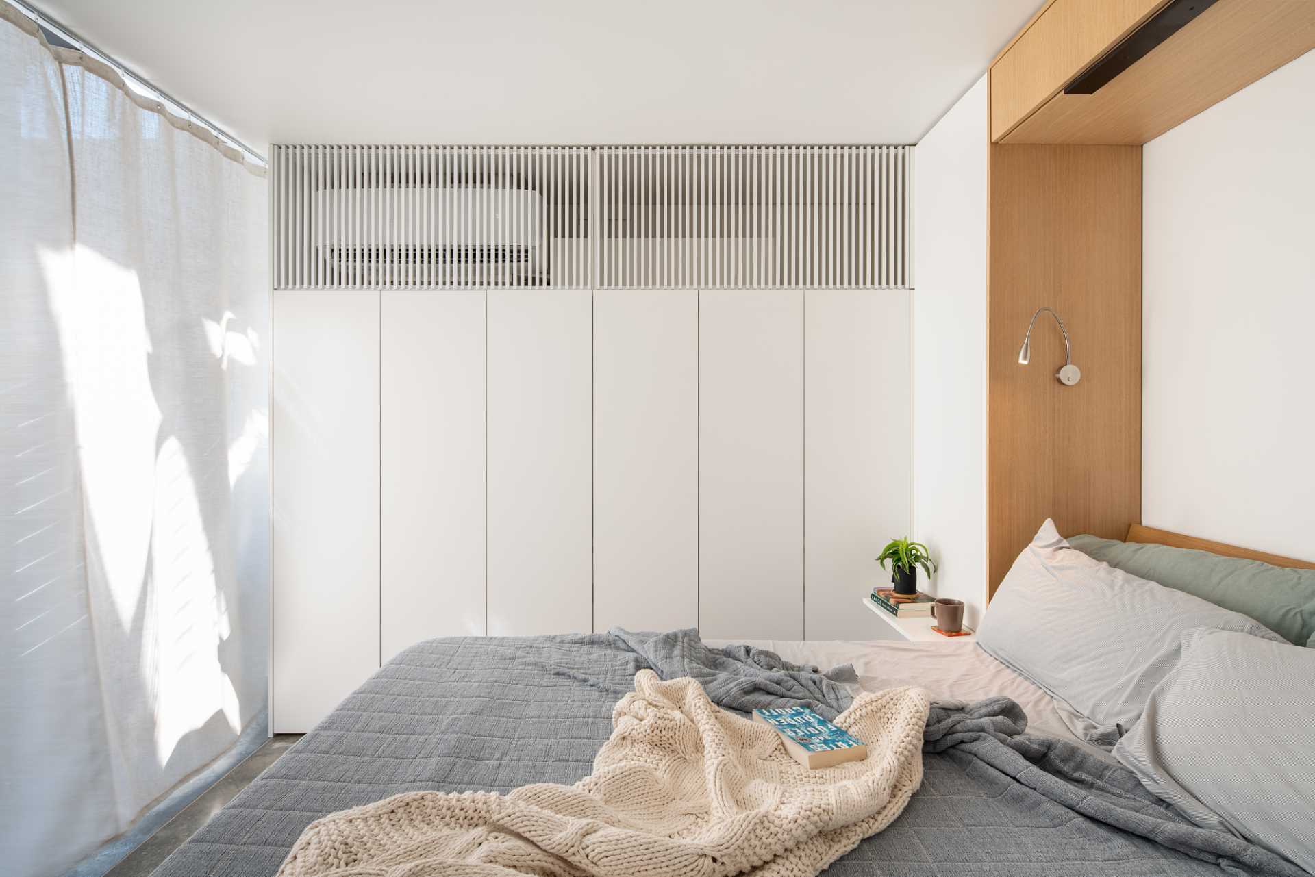 The wood accent wall hides a fold-down bed, while a curtain allows the space to be turned into a bedroom.