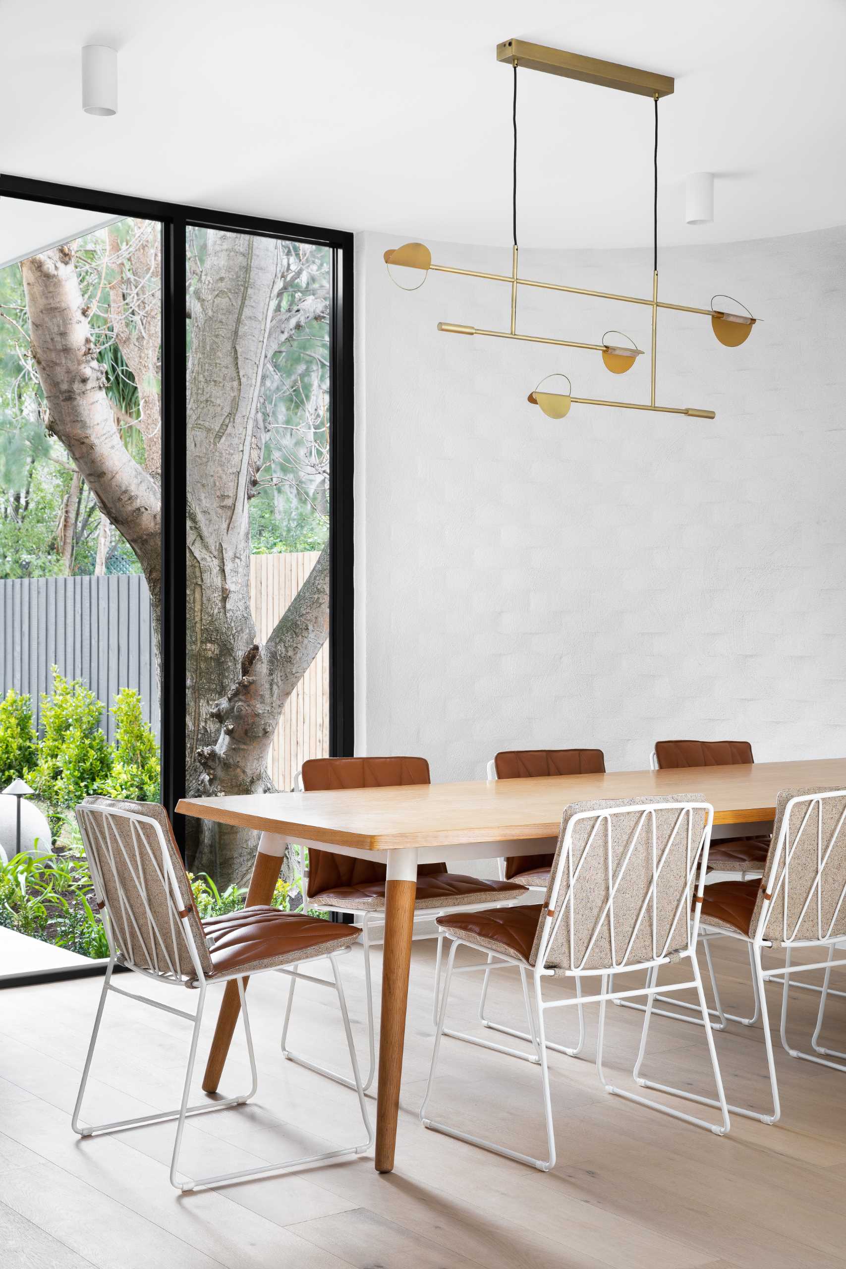 A modern dining room with wood and leather furniture.