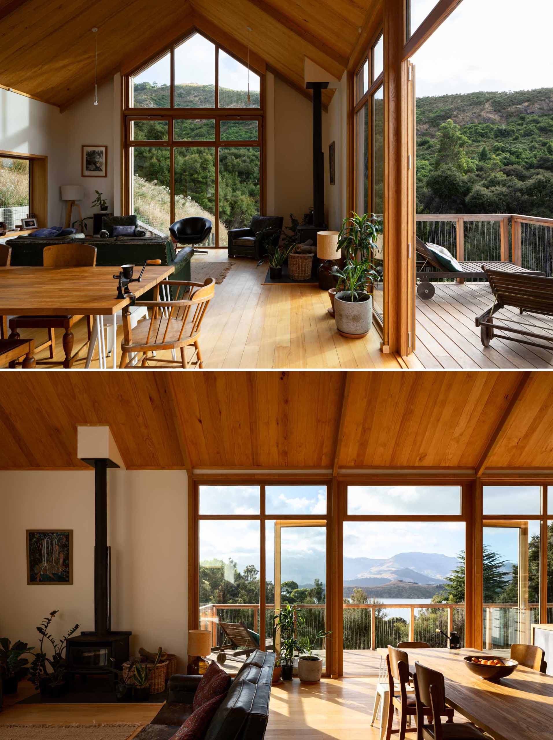 The main floor of this modern home has an open-plan living room and dining area, which open to the deck, while the full-height ceilings of the gable roof create a light-filled and comfortable interior.