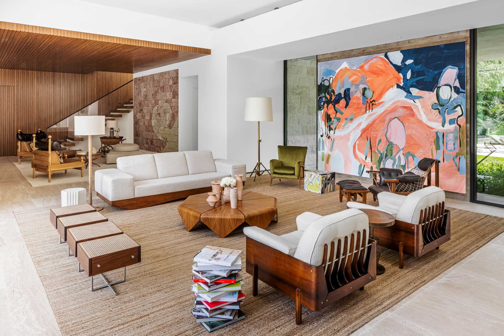 This modern living room includes a Janaina Tschäpe painting, Amir Nikravan sculpture, Jorge Zalszupin coffee table, and Jean Gillon armchairs.