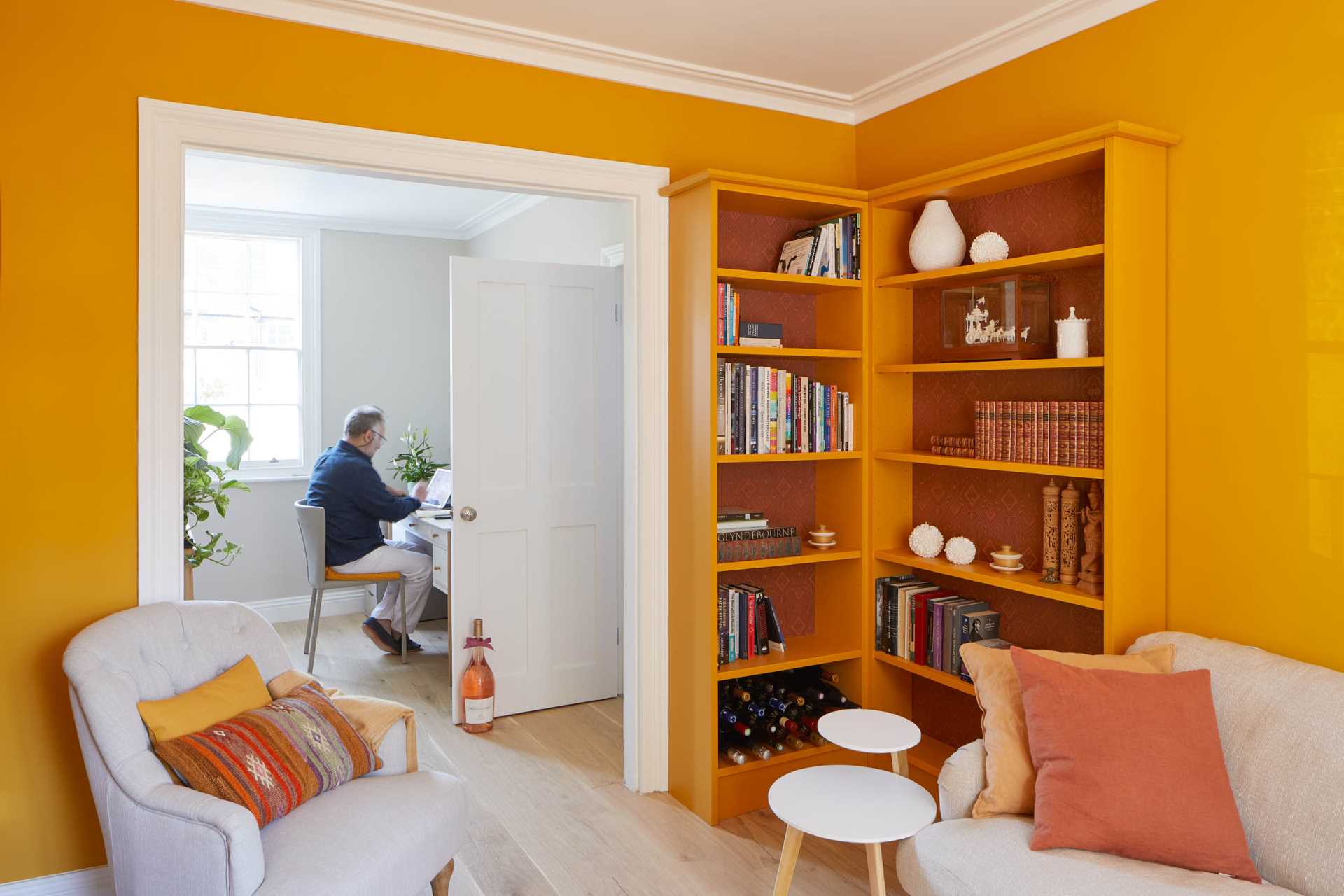 Orange was the color of choice for a sitting room, with a pair of bookshelves that match the wall. 