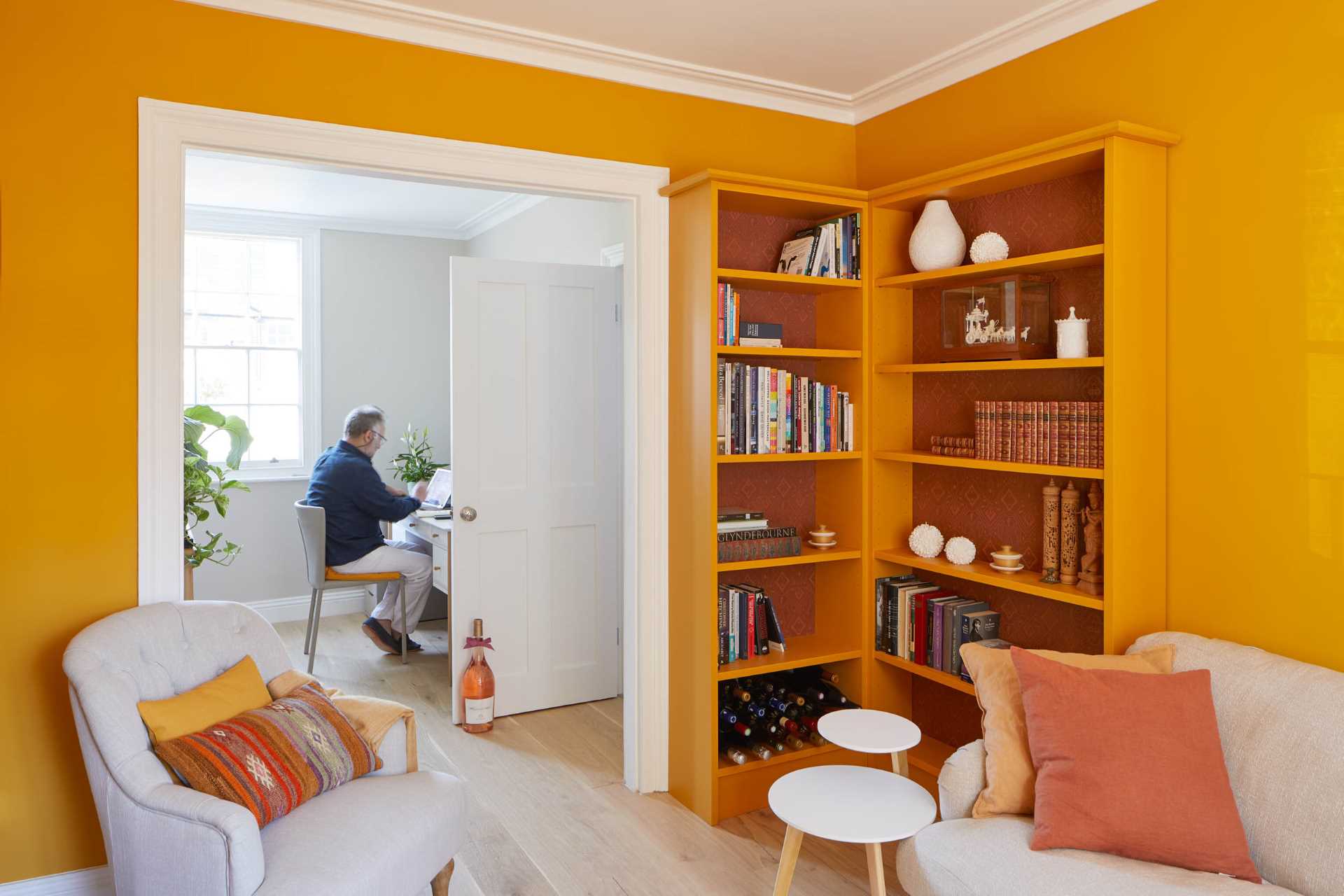 Orange was the color of choice for a sitting room, with a pair of bookshelves that match the wall.