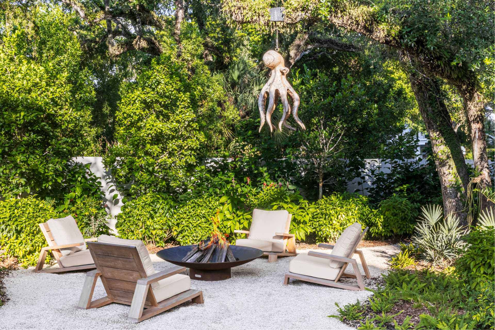 An outdoor seating area that features a fire pit and evocative sculpture hanging above.