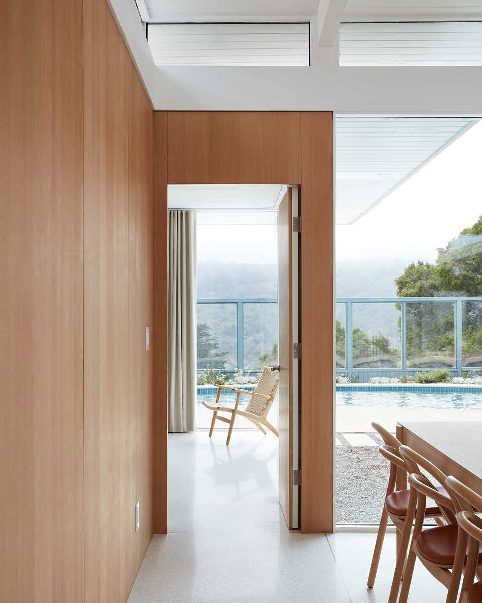 A remodeled Eichler home with cream-colored terrazzo floor, light ceilings, natural wood, and a muted palette.