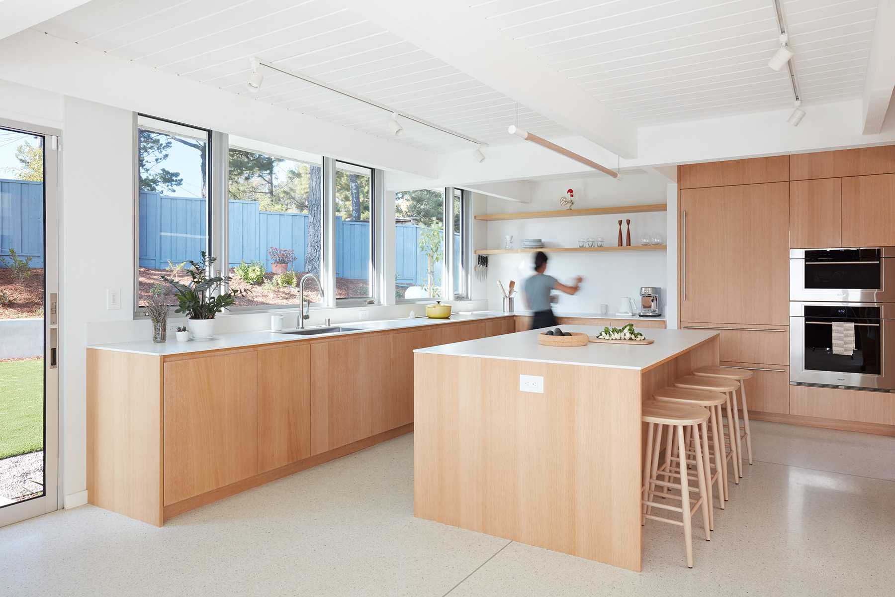 A modern light wood and white kitchen.