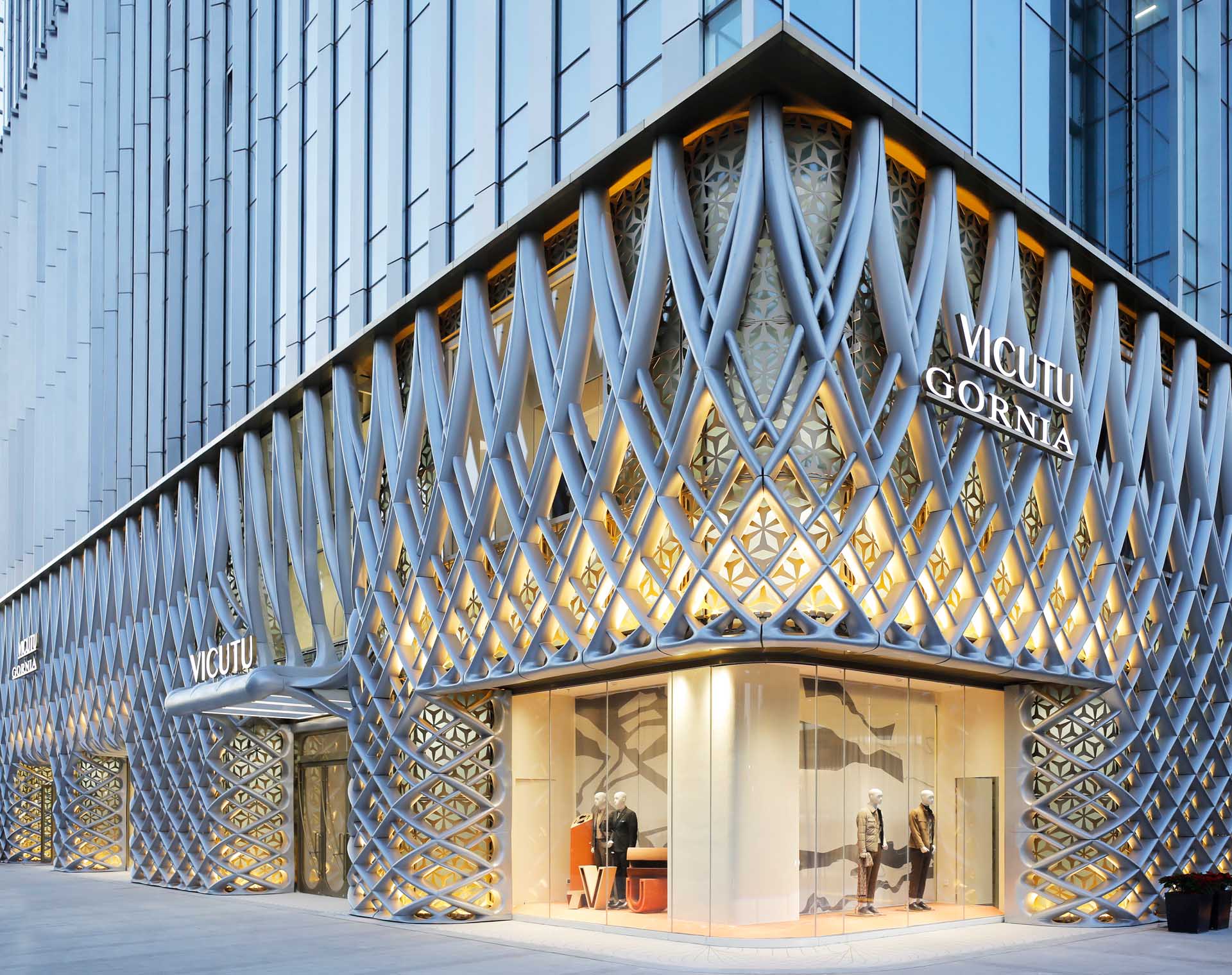 Similar to the nature of tailoring flat fabrics into three-dimensional garments, the construction of the facade comes from an innovative fabrication process of bending and flexing aluminum sheets into doubly curved geometries.