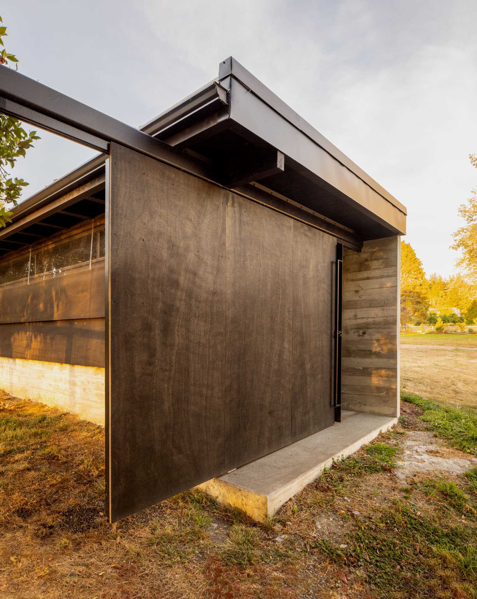 A modern boathouse with storage and a large sliding door.