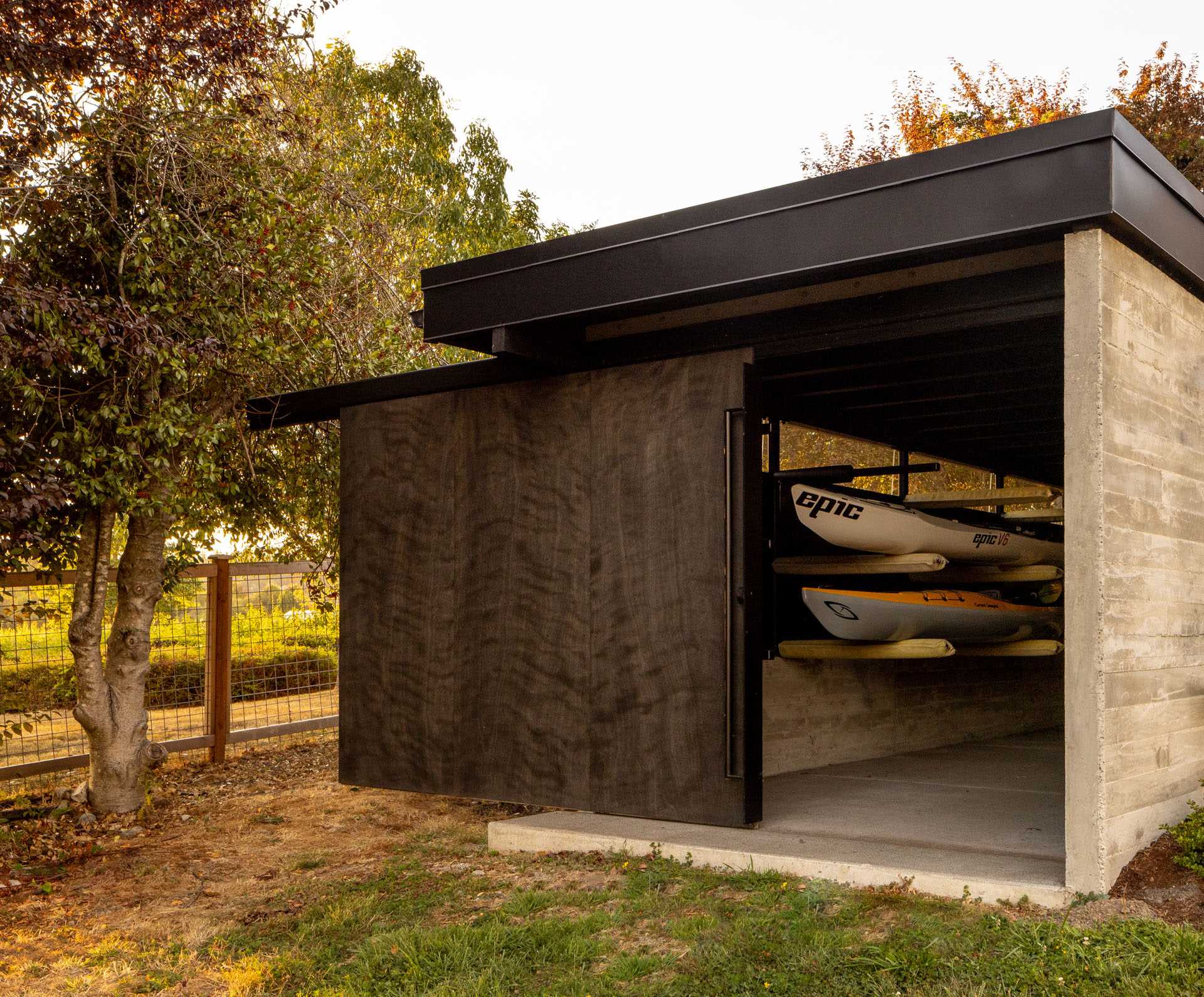 A modern boathouse with storage and a large sliding door.