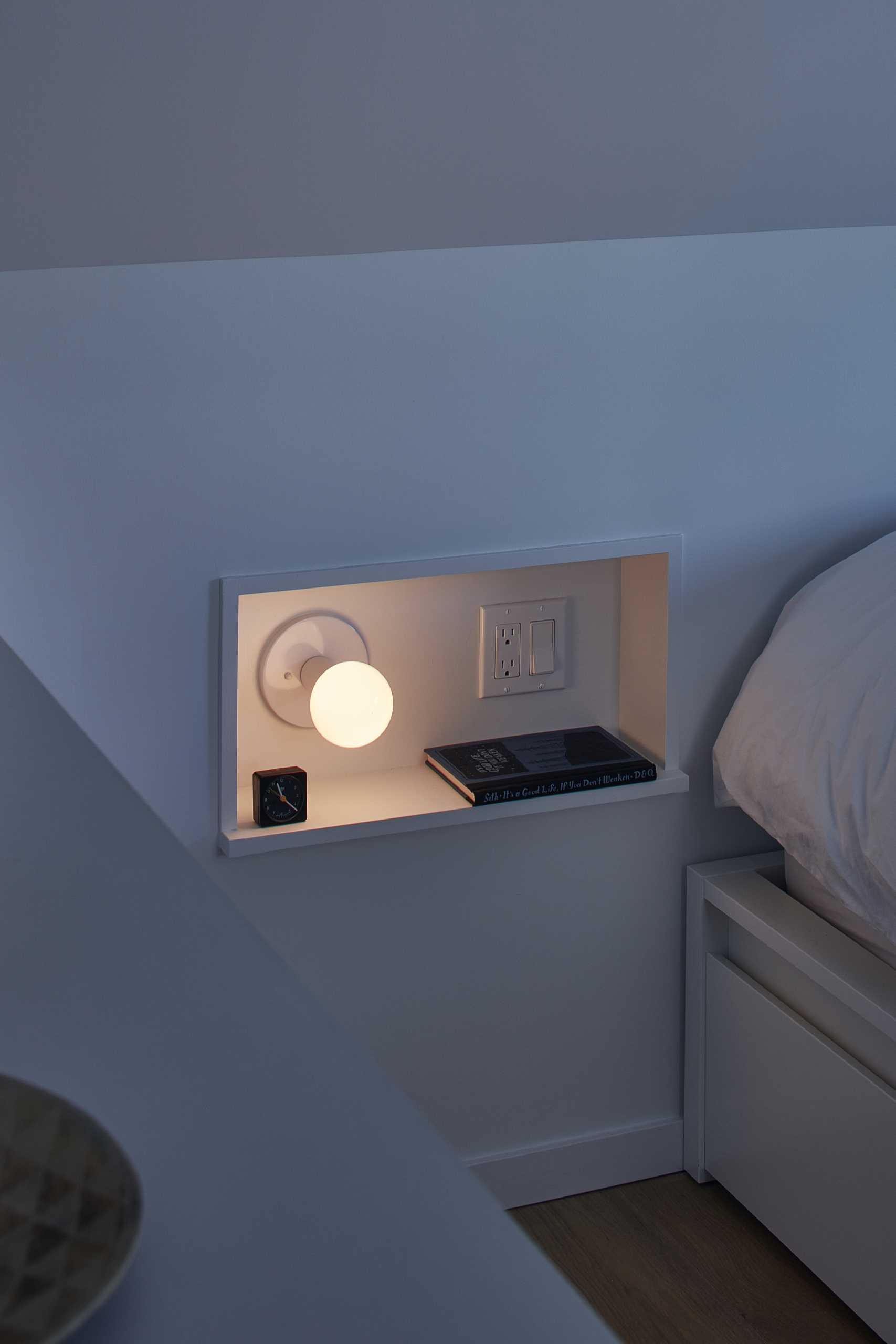 A small niche has been designed to act as a bedside table.