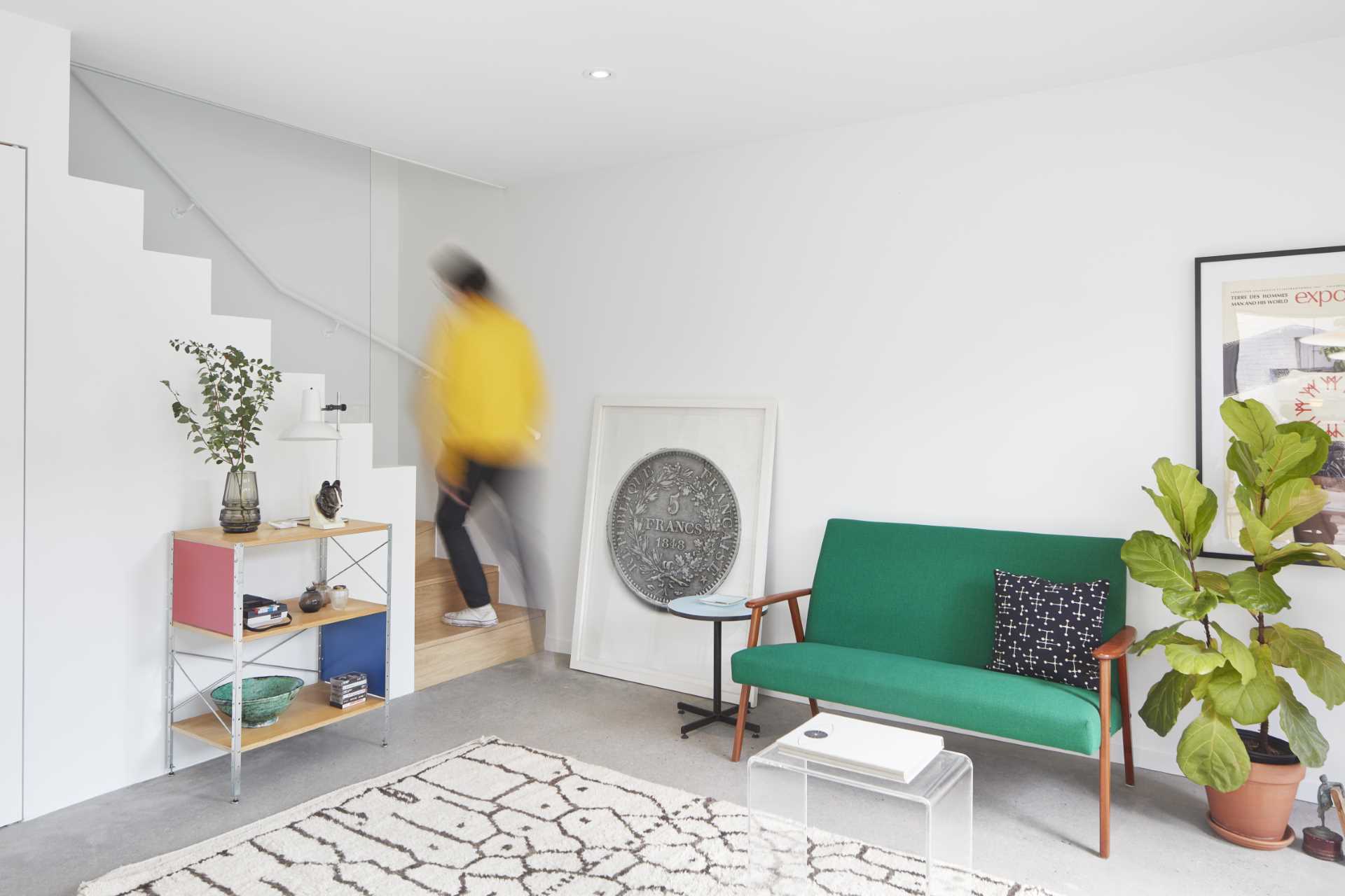 A small laneway house with wood stairs that lead to a bedroom.