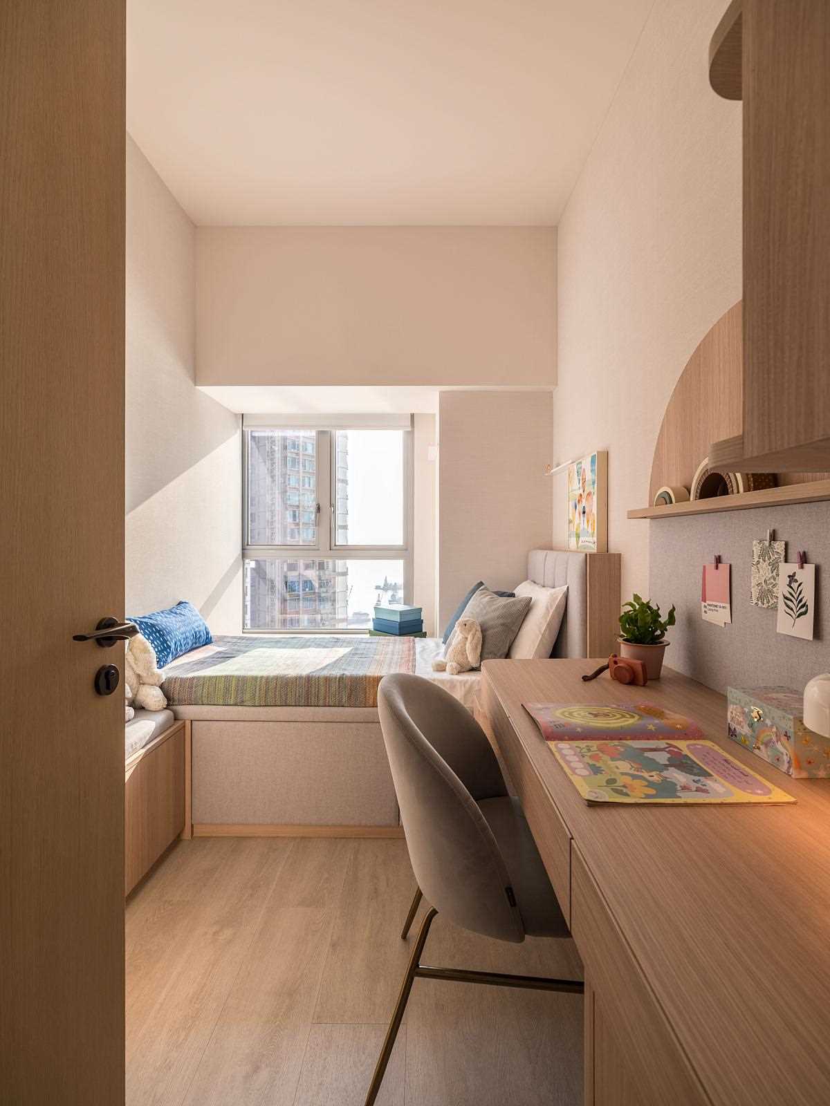 A modern and small kids room with a built-in desk.