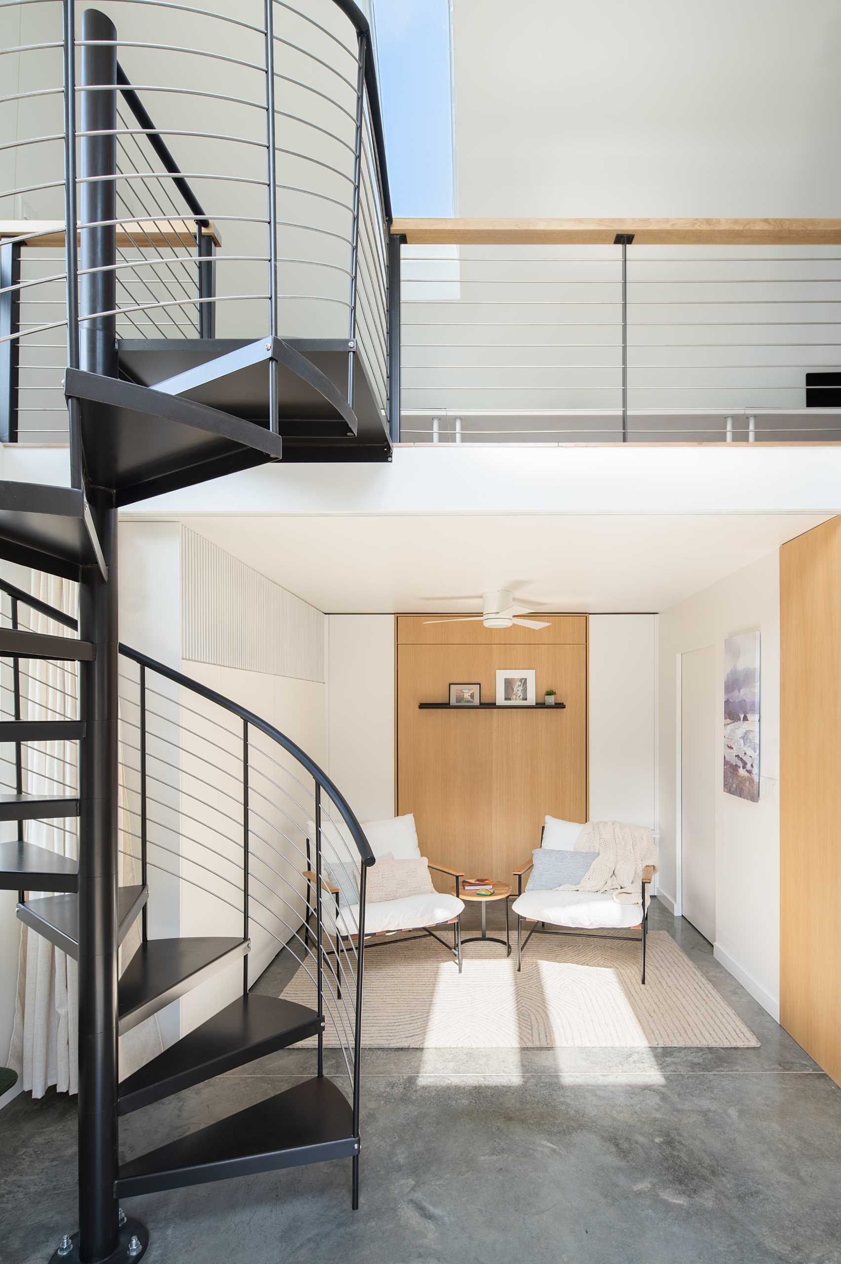 A small sitting area with a wall of closet space and a fold-down bed hidden behind a wood accent wall.