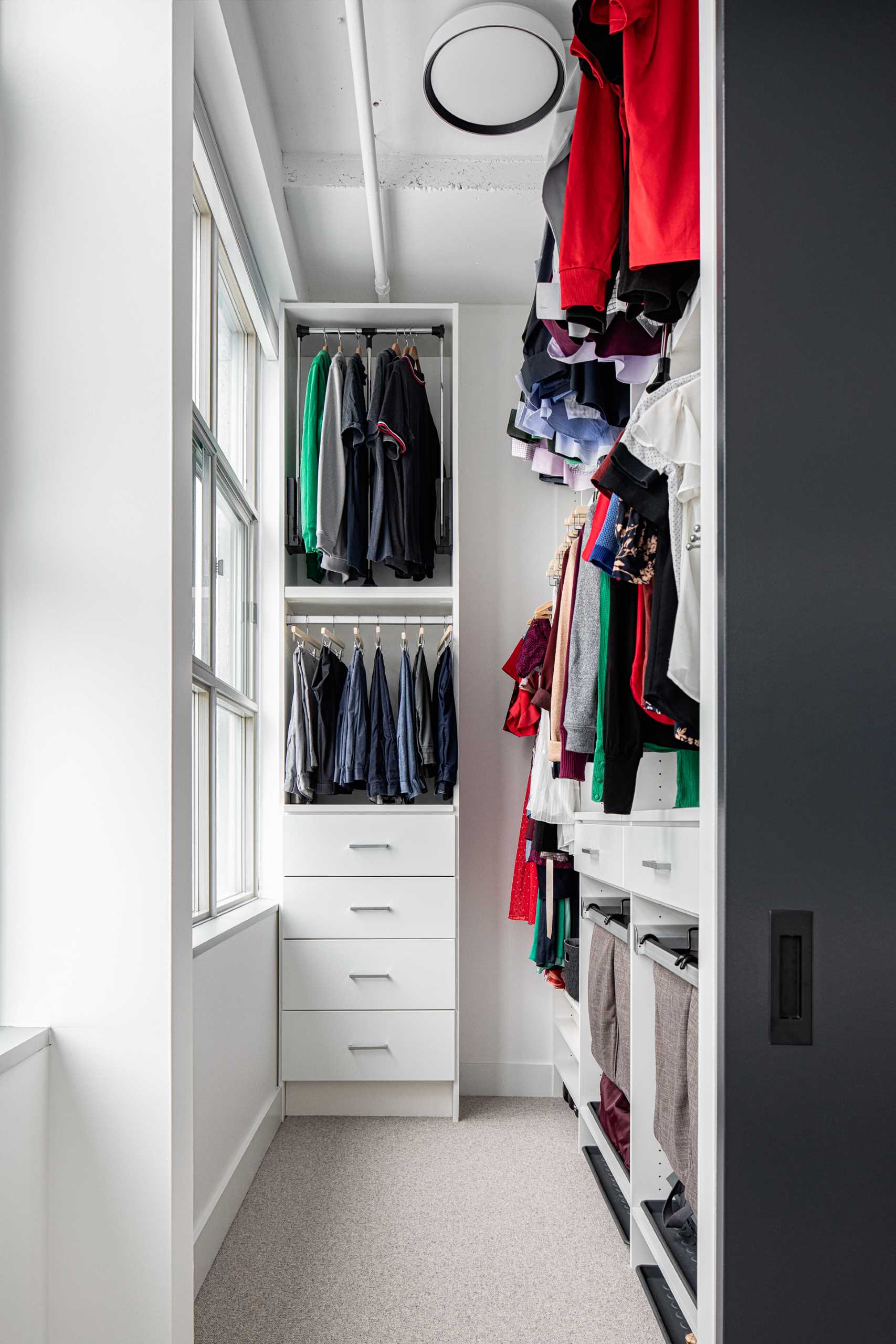 A walk-in closet makes use of the high ceilings to have the most storage space possible.