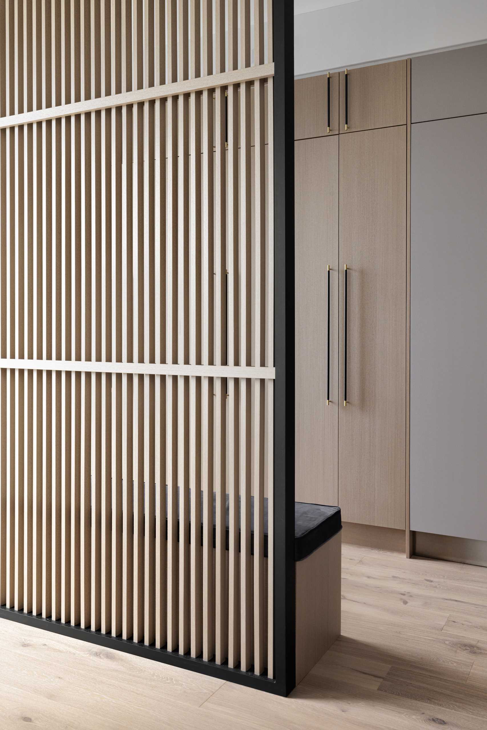 A wood slat partition creates space for a mudroom.