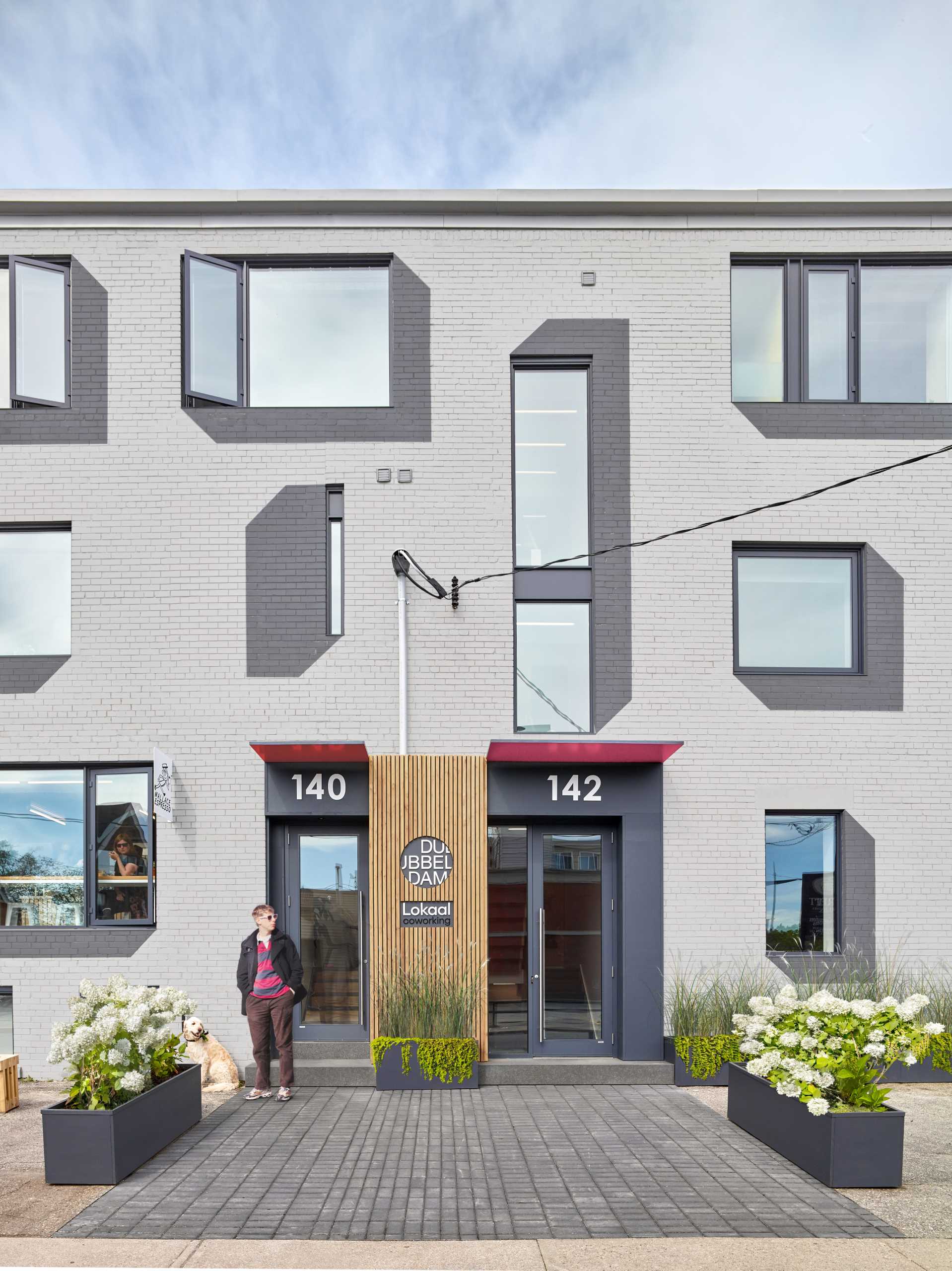 A remodeled brick building with painted drop shadows surrounding the windows.