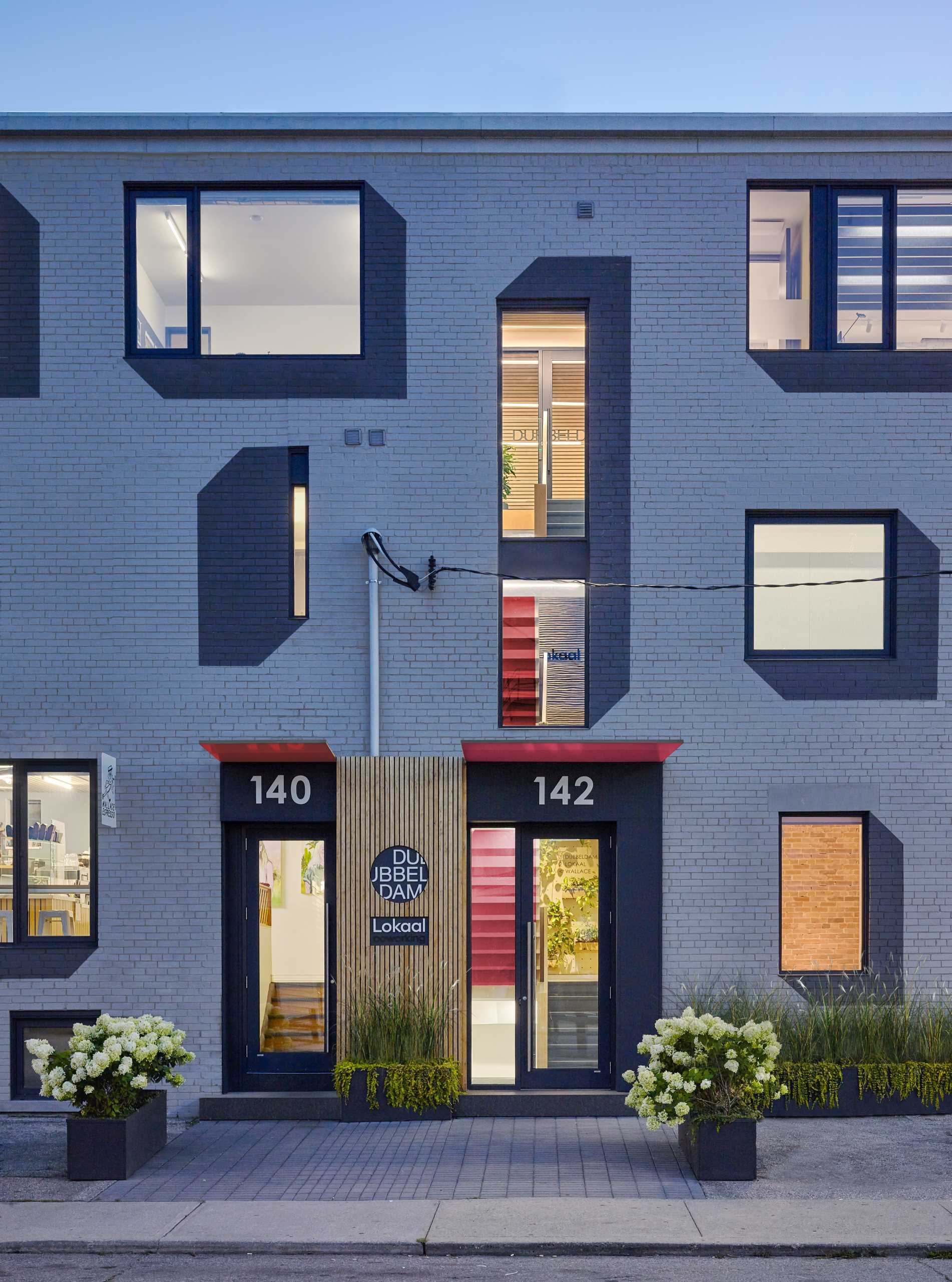 A remodeled brick building with painted drop shadows surrounding the windows.