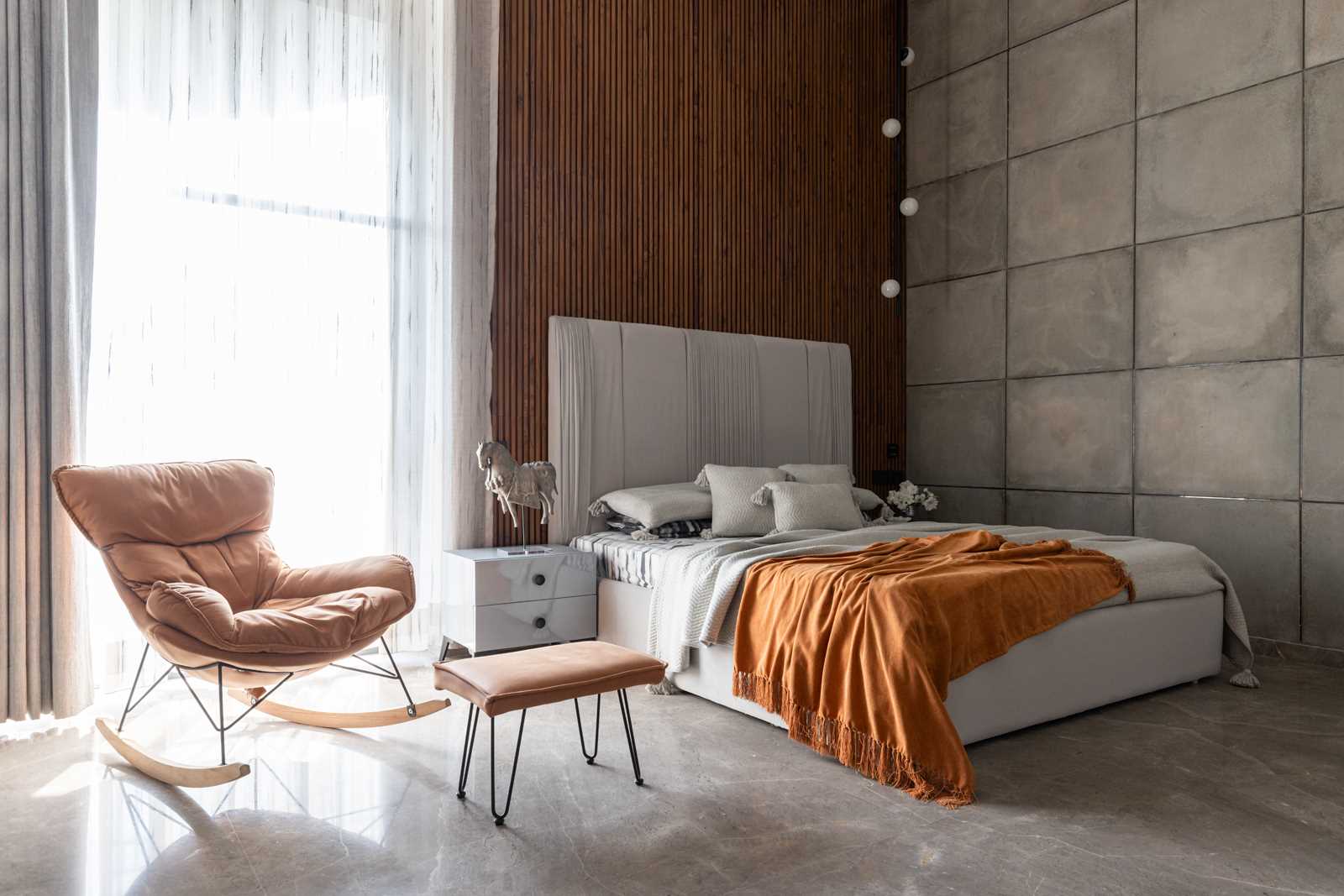 A contemporary bedroom with a wood accent wall.