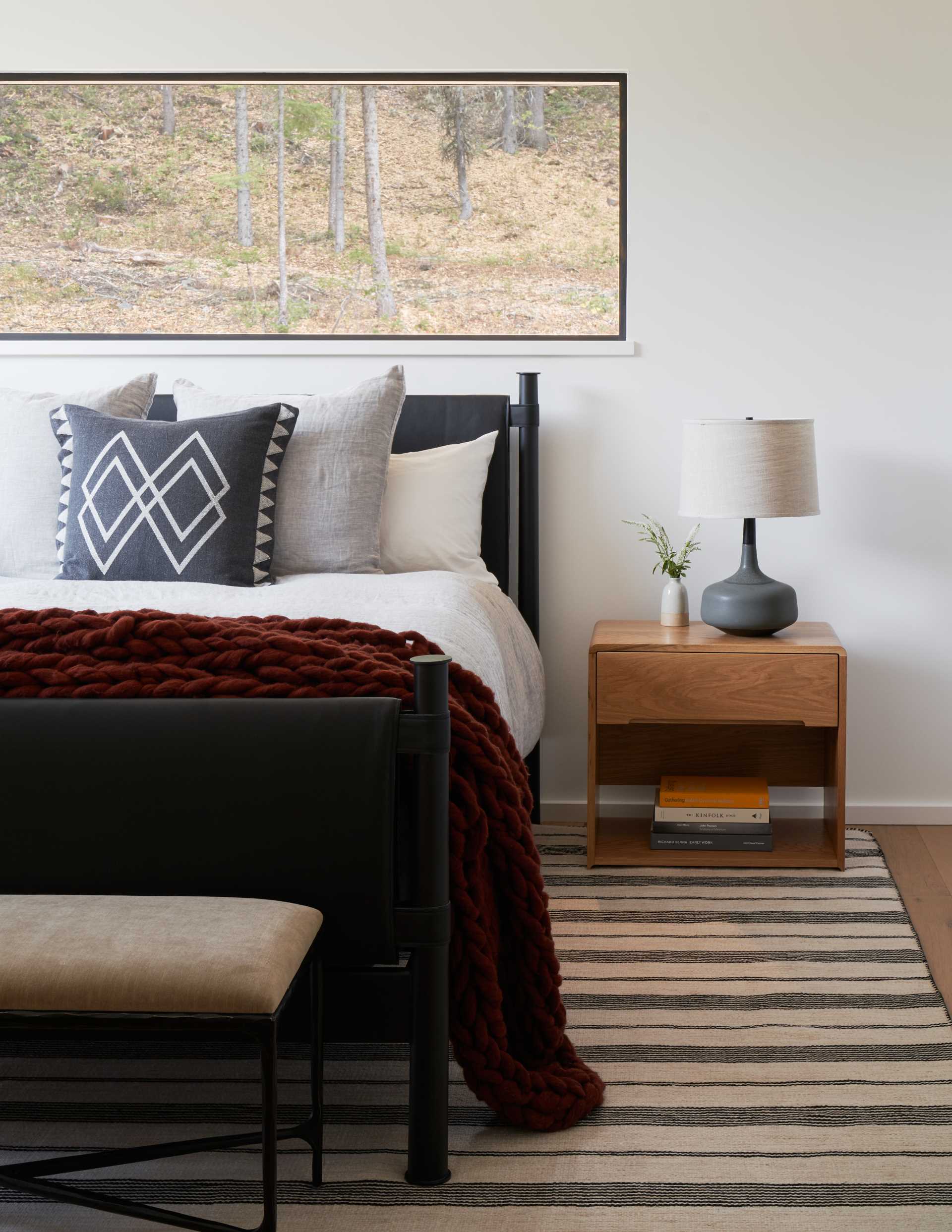 A contemporary bedroom with a black bed frame.