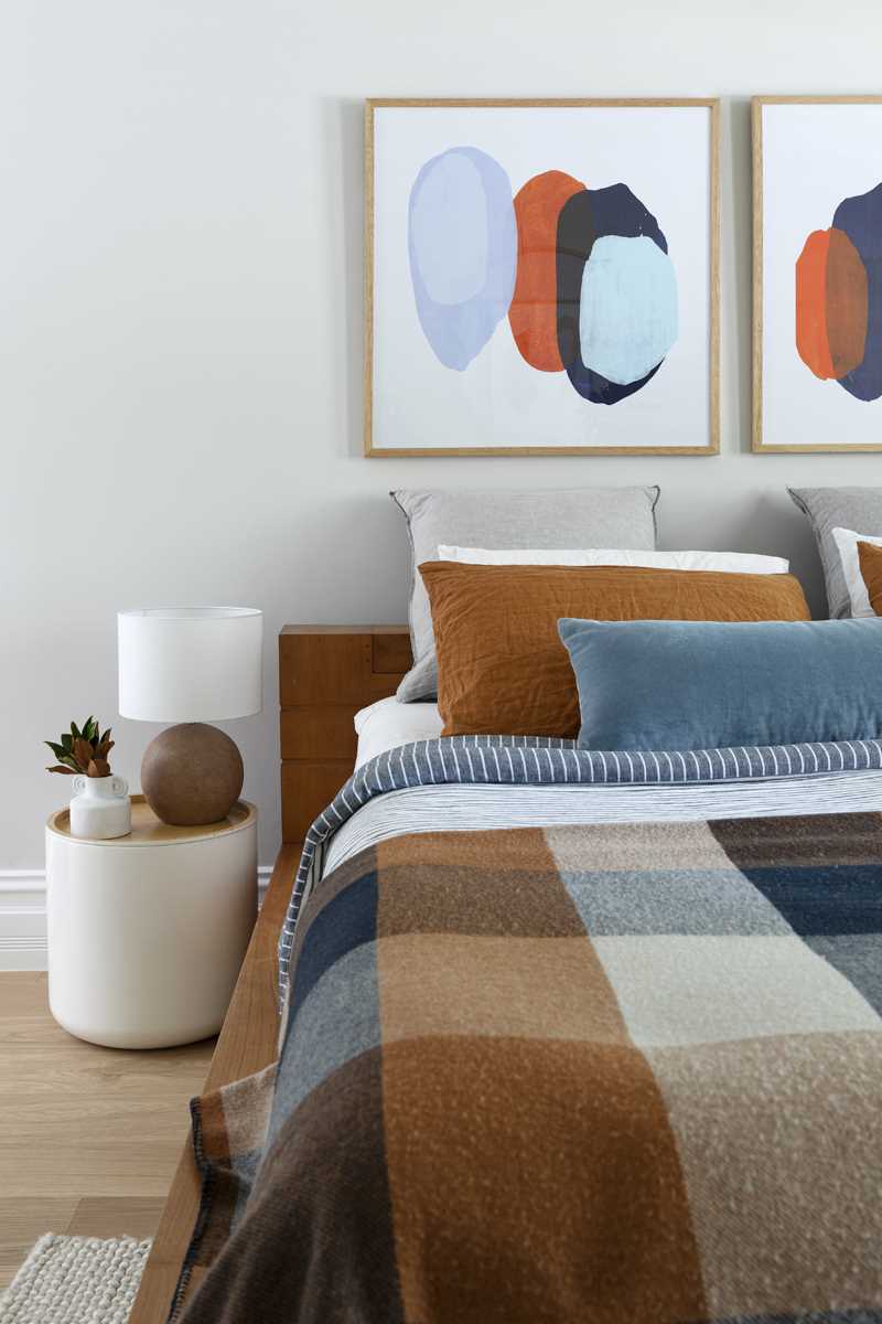 A contemporary bedroom with a colour palette of rusty orange, blues, and browns.