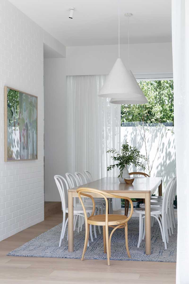 A modern dining area with white colour palette and wood accents.