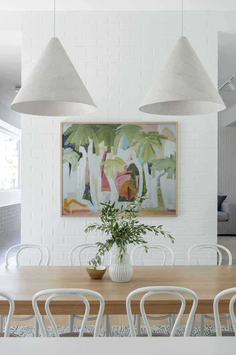 A modern dining area with white colour palette and wood accents.
