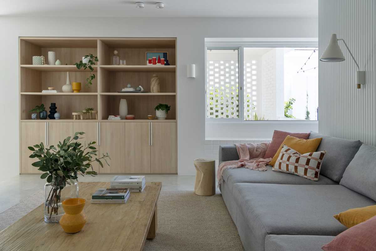 A modern living room with built-in cabinetry and a grey couch.