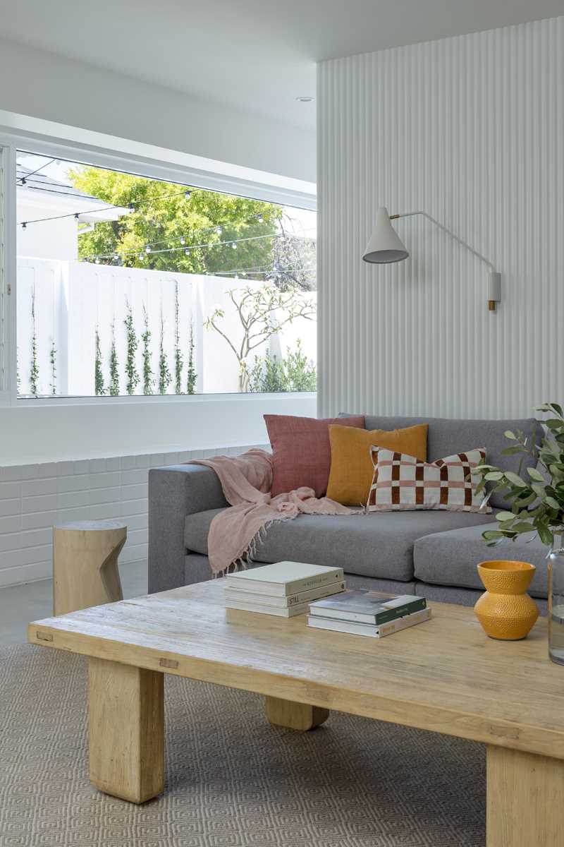 A modern living room with built-in cabinetry and a grey couch.